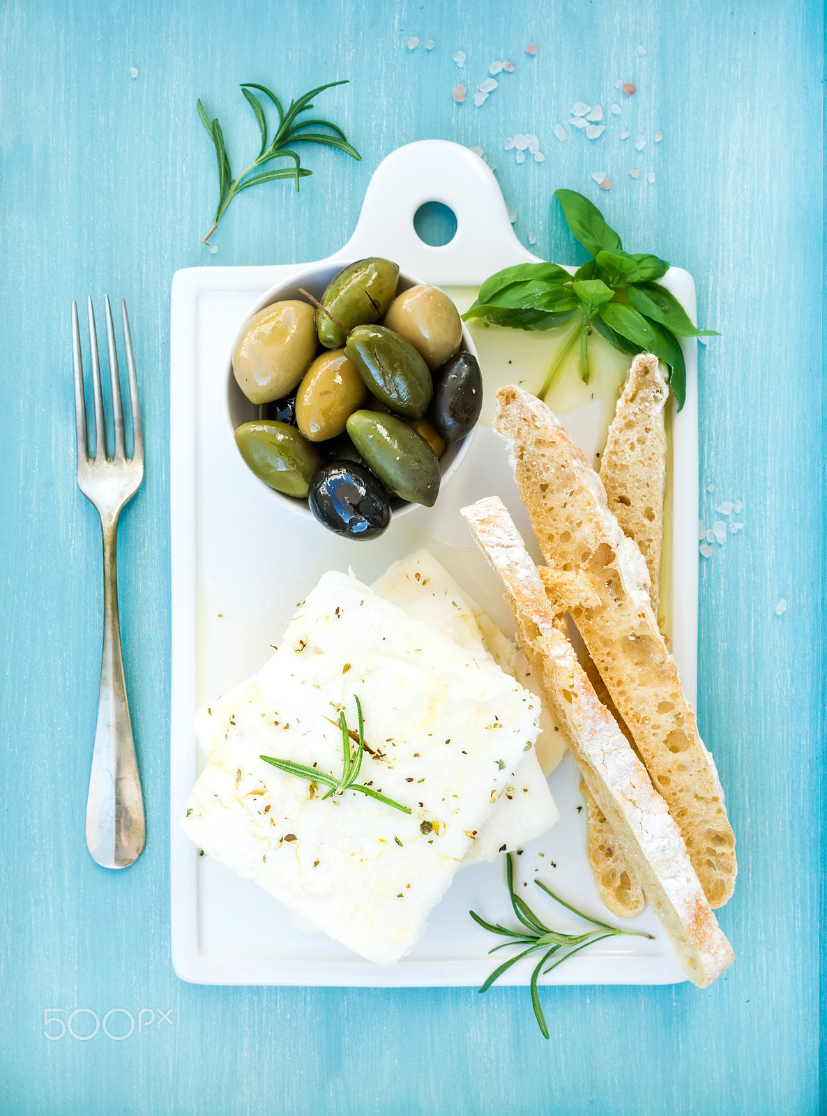 Nikon D610 + ZEISS Distagon T* 35mm F2 sample photo. Fresh feta cheese with olives, basil, rosemary and bread slices on white ceramic serving board over  photography