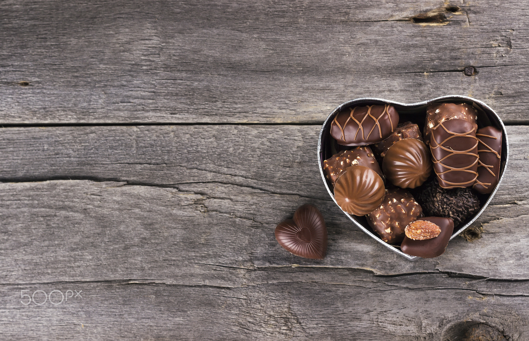 Chocolates in a box in form of heart on a dark background