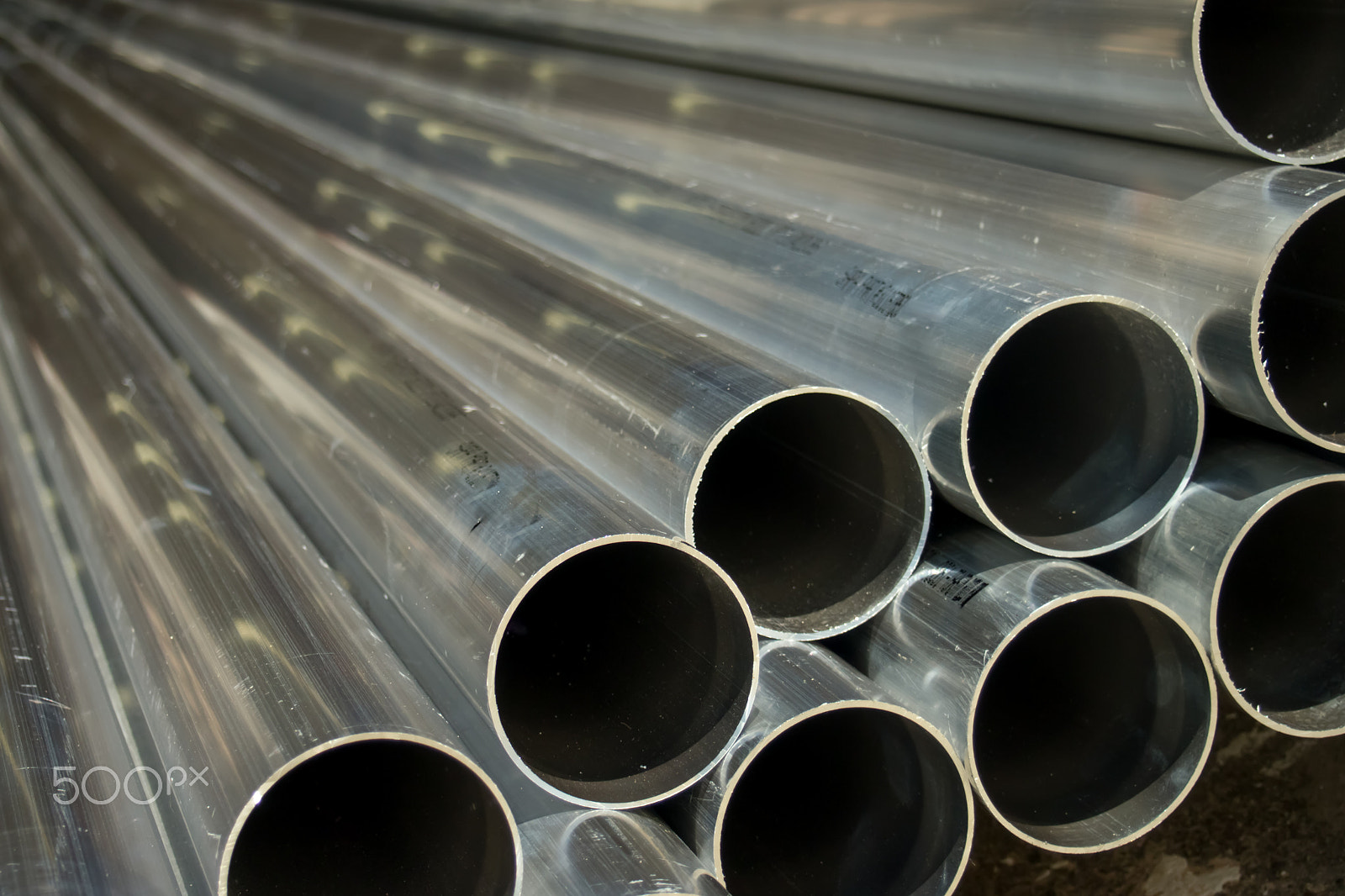 Olympus M.Zuiko Digital 14-42mm F3.5-5.6 II sample photo. Stack of many pipes at the construction site photography