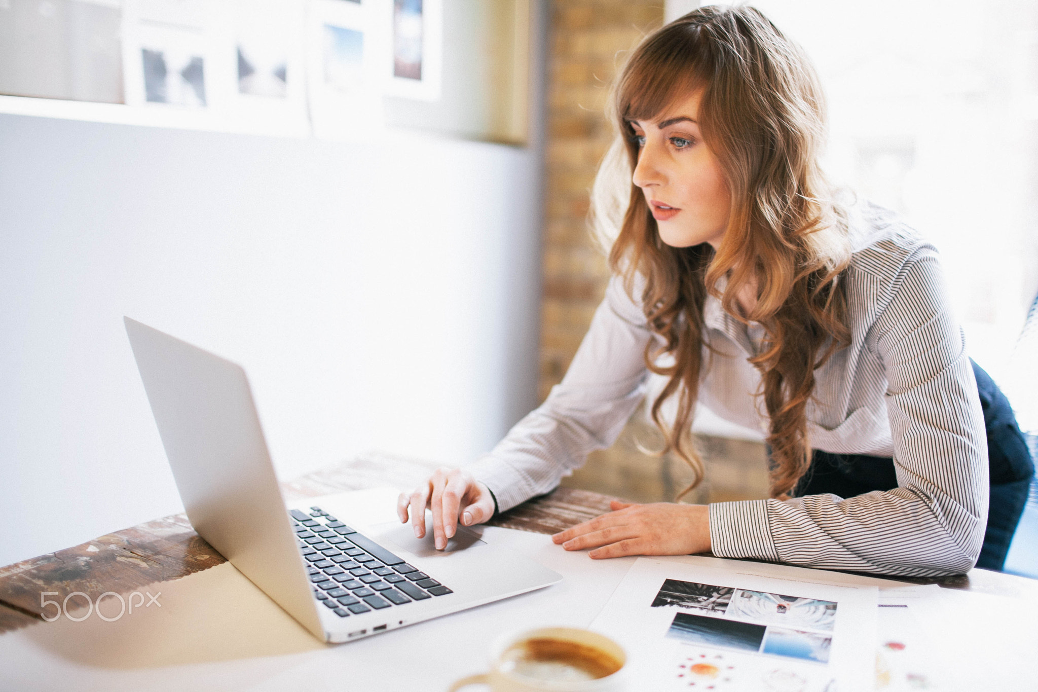 Businesswoman working at laptop in meeting room.