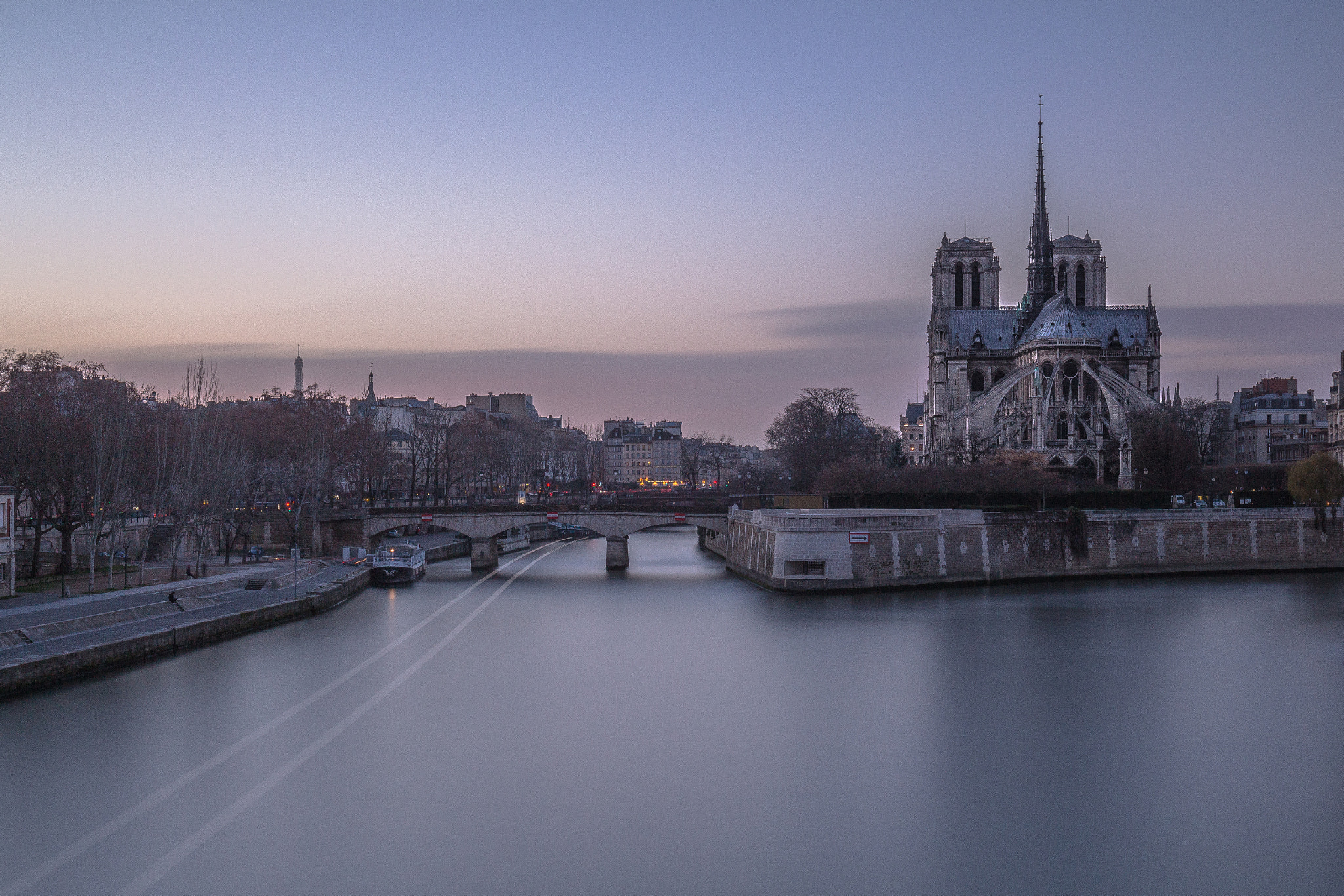 Canon EOS 700D (EOS Rebel T5i / EOS Kiss X7i) + Canon EF 16-35mm F4L IS USM sample photo. Notre dame cathedral on the seine at sunset photography