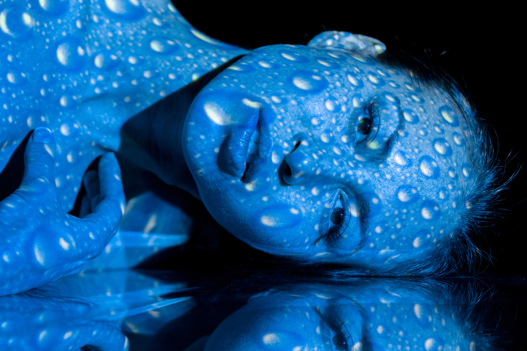 The body of woman with blue pattern and its reflection