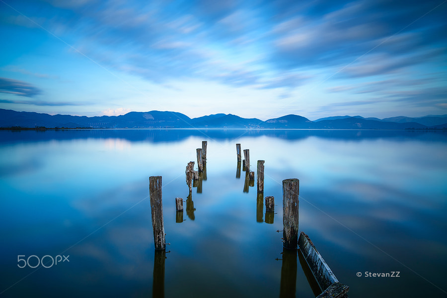 Nikon D800E + ZEISS Distagon T* 21mm F2.8 sample photo. Wooden pier or jetty remains on a blue lake sunset photography