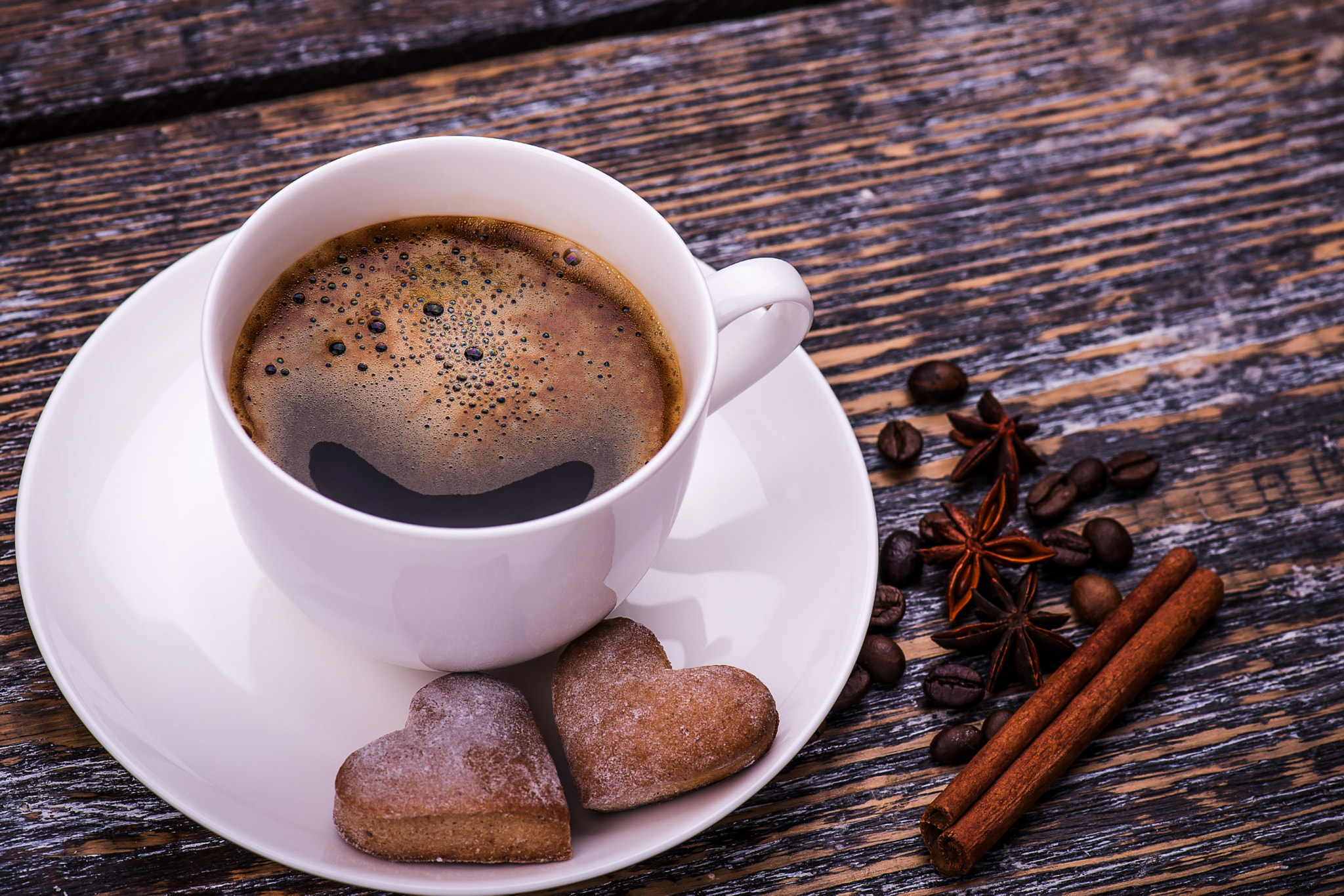 Coffee cup and beans on a wooden table. Dark background.