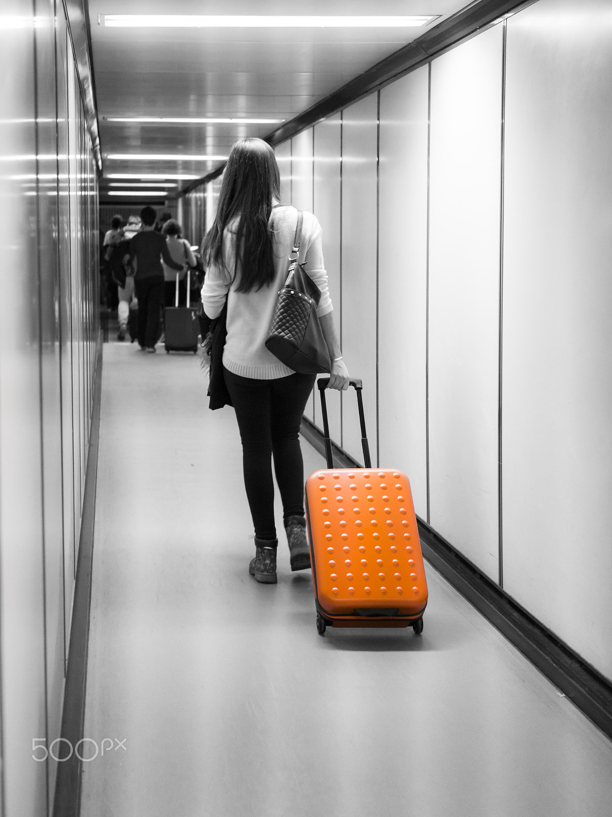 Panasonic Lumix DMC-GH3 + LUMIX G 25/F1.7 sample photo. Woman with orange suitcase on jetway photography