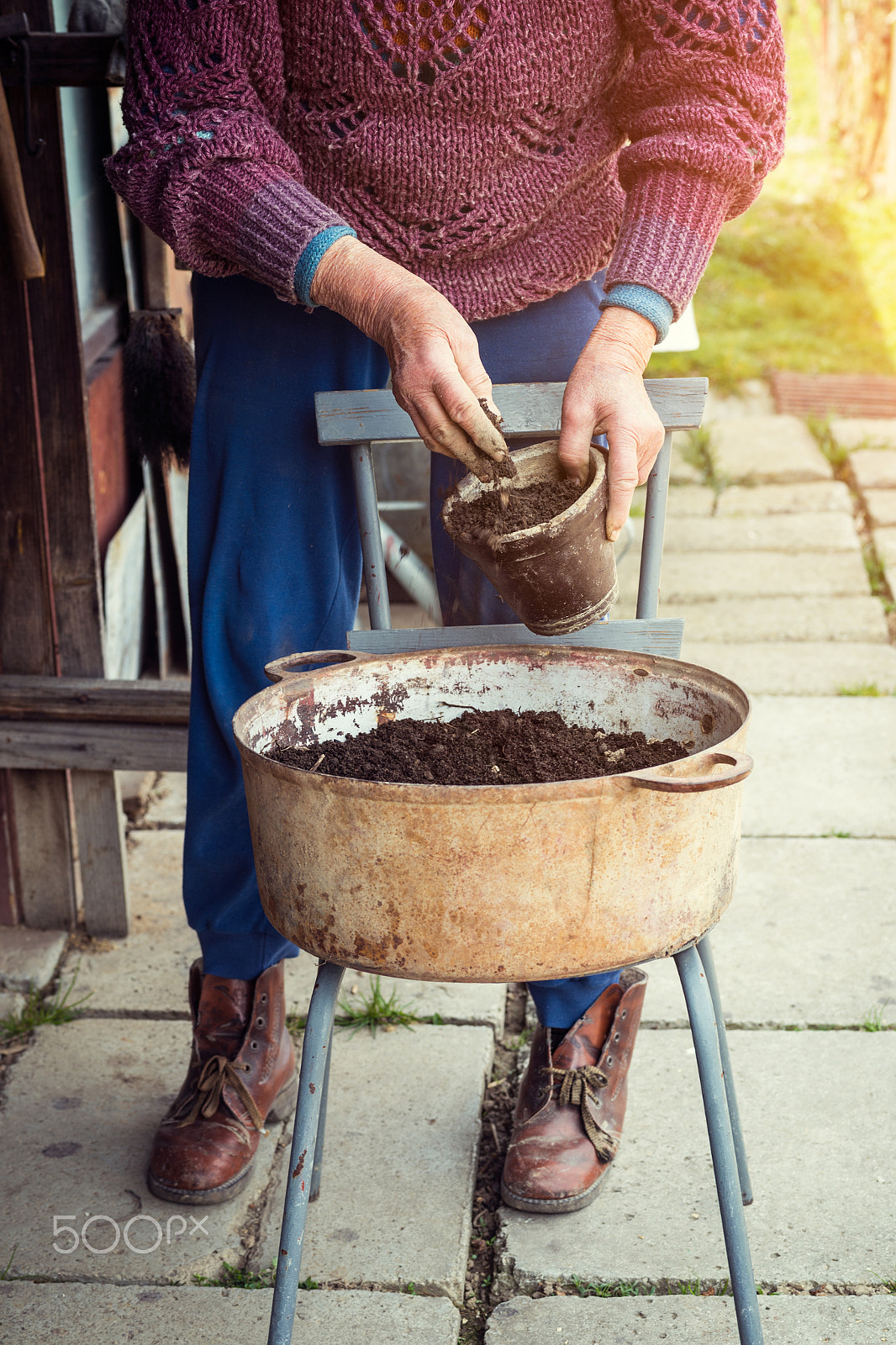 Nikon D4S + Sigma 70mm F2.8 EX DG Macro sample photo. Old woman filling a pot with fresh soil. symbol of spring and clean eating concept. photography