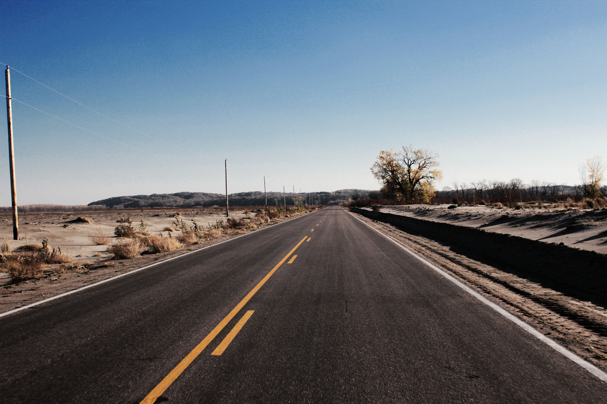 Canon EF 28mm F1.8 USM sample photo. On a little old road to no where after some flooding. shot while cruising along at 60mph.  photography