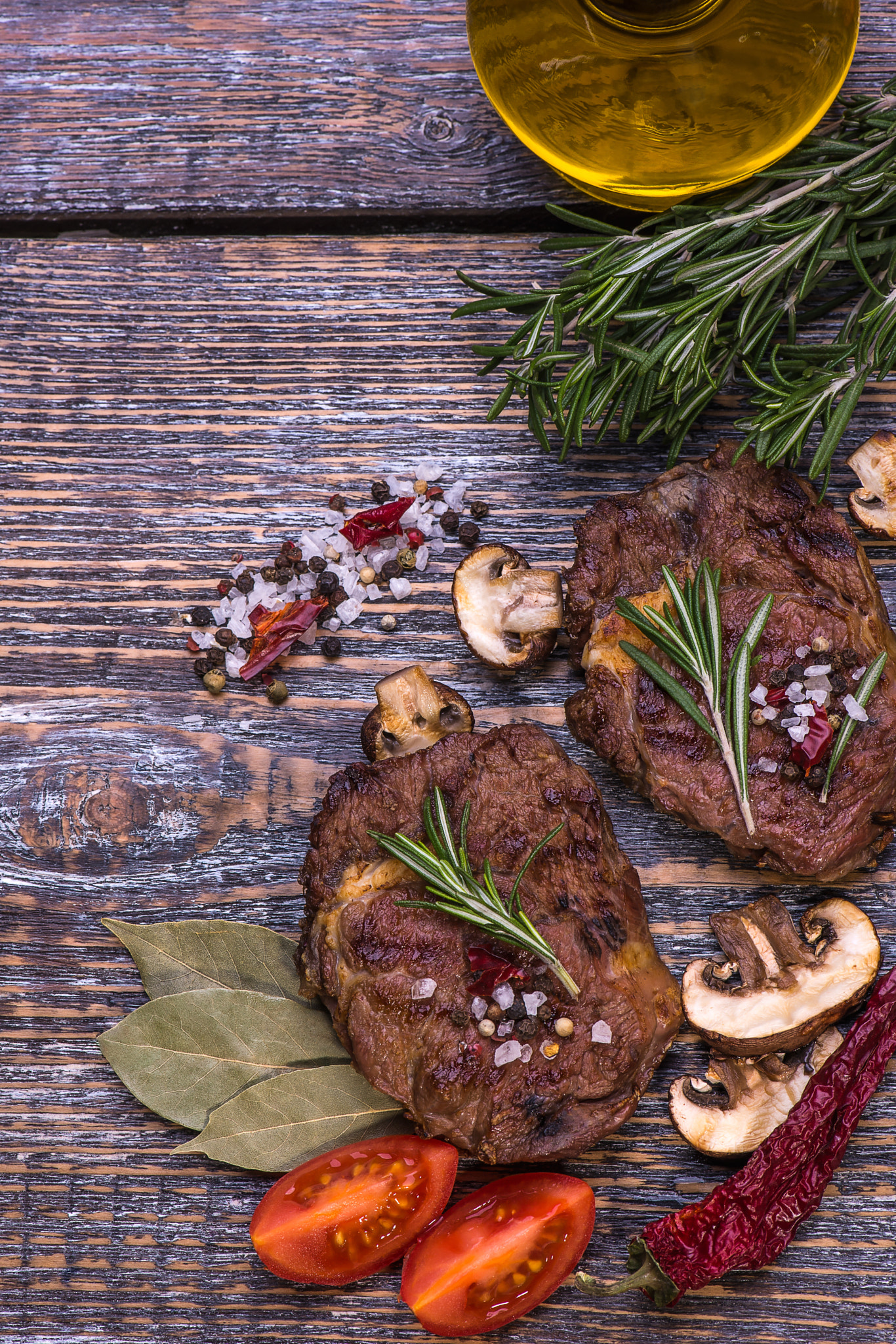 Raw Beef Steak, salt, pepper, garlic, rosemary  on the black board, background.