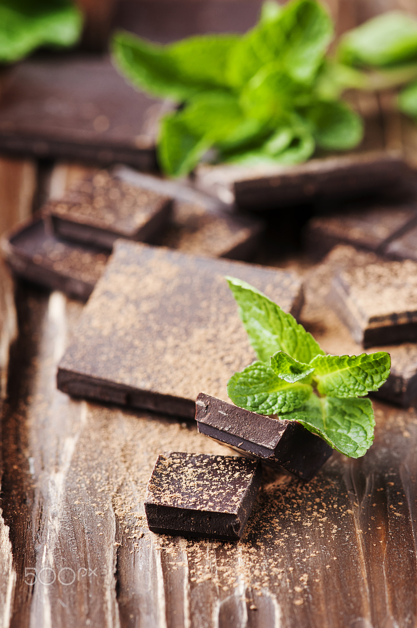 Dark chocolate and green mint on the wooden table