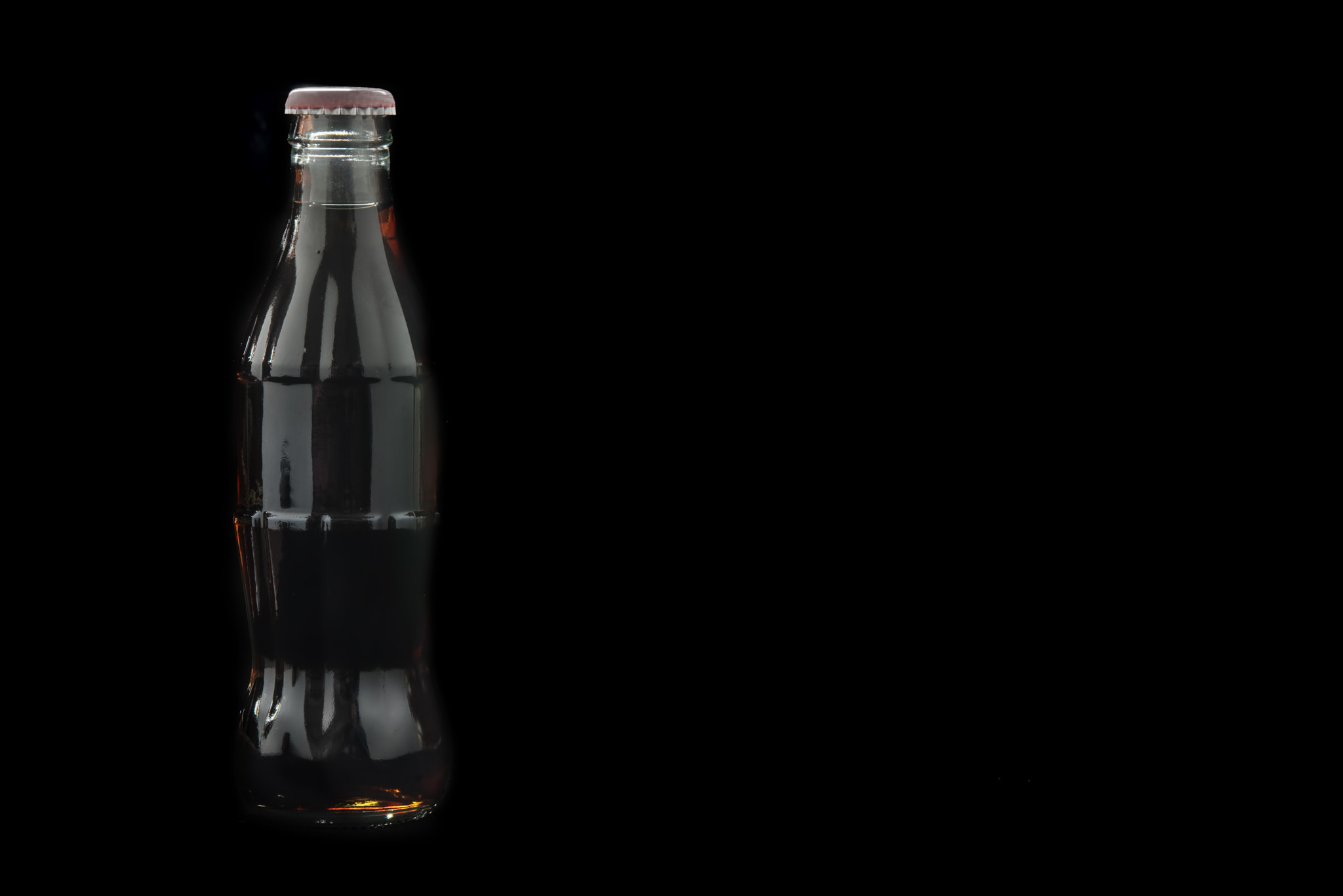 Nikon D750 + AF Micro-Nikkor 105mm f/2.8 sample photo. Bottle of coca cola glass soda isolated on black background photography