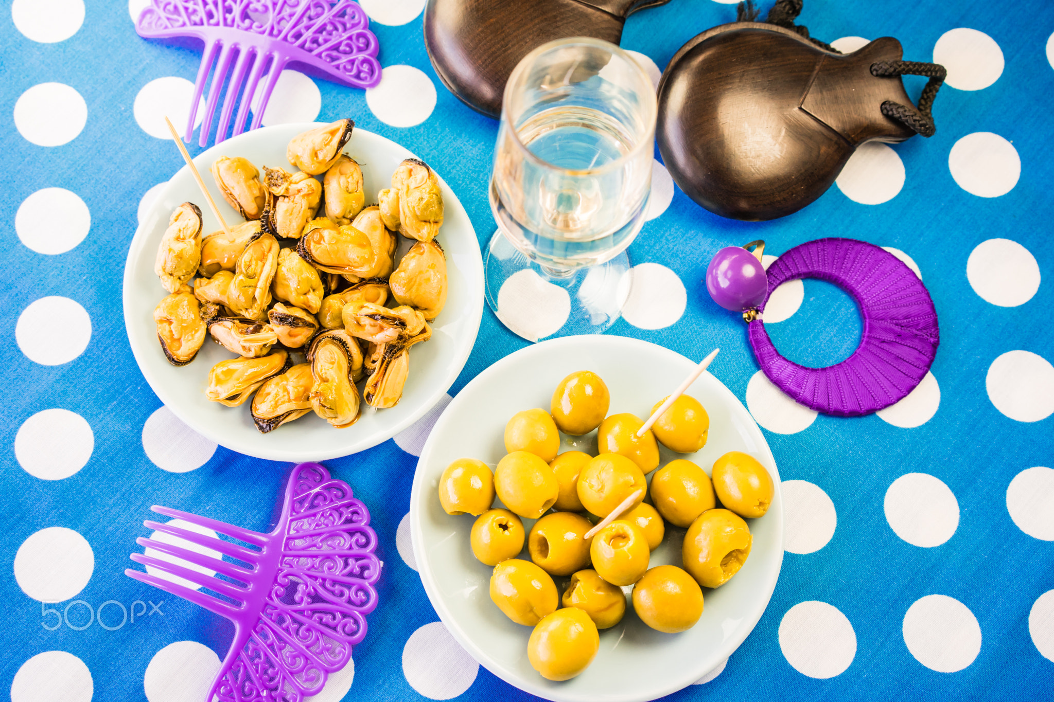 Close-up of green olives, mussels and costume jewelry