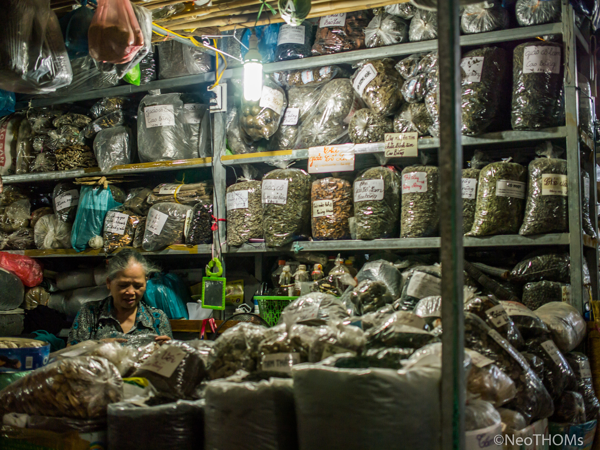 Panasonic Lumix DMC-GF6 + Olympus M.Zuiko Digital 25mm F1.8 sample photo. Old woman in spices shop photography