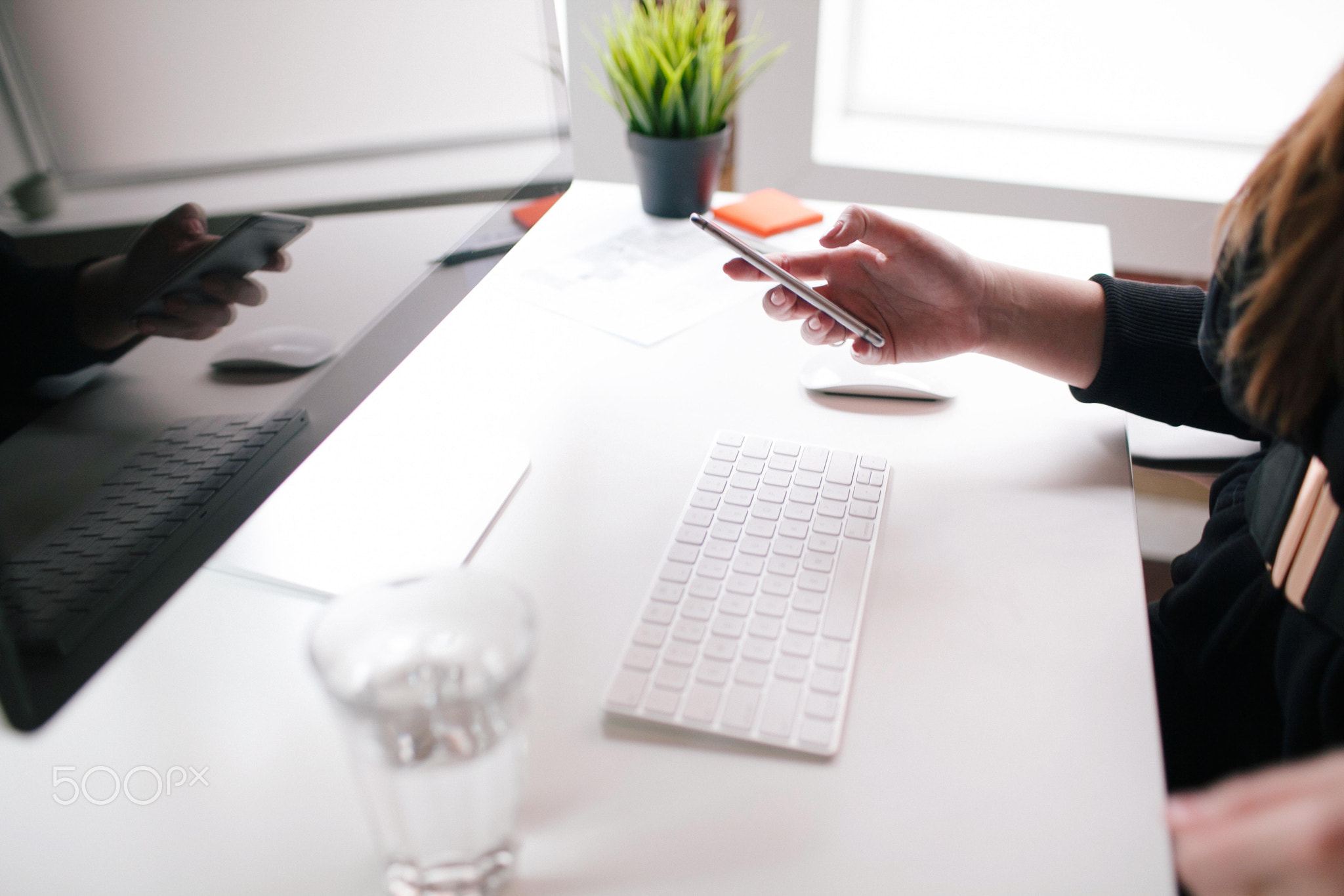 Businesswoman using mobile device at desk.
