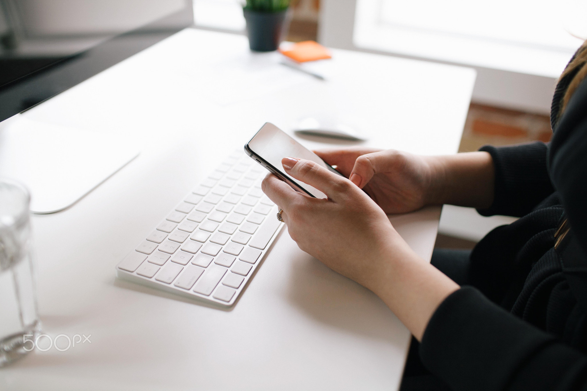 Businesswoman using mobile device at desk.