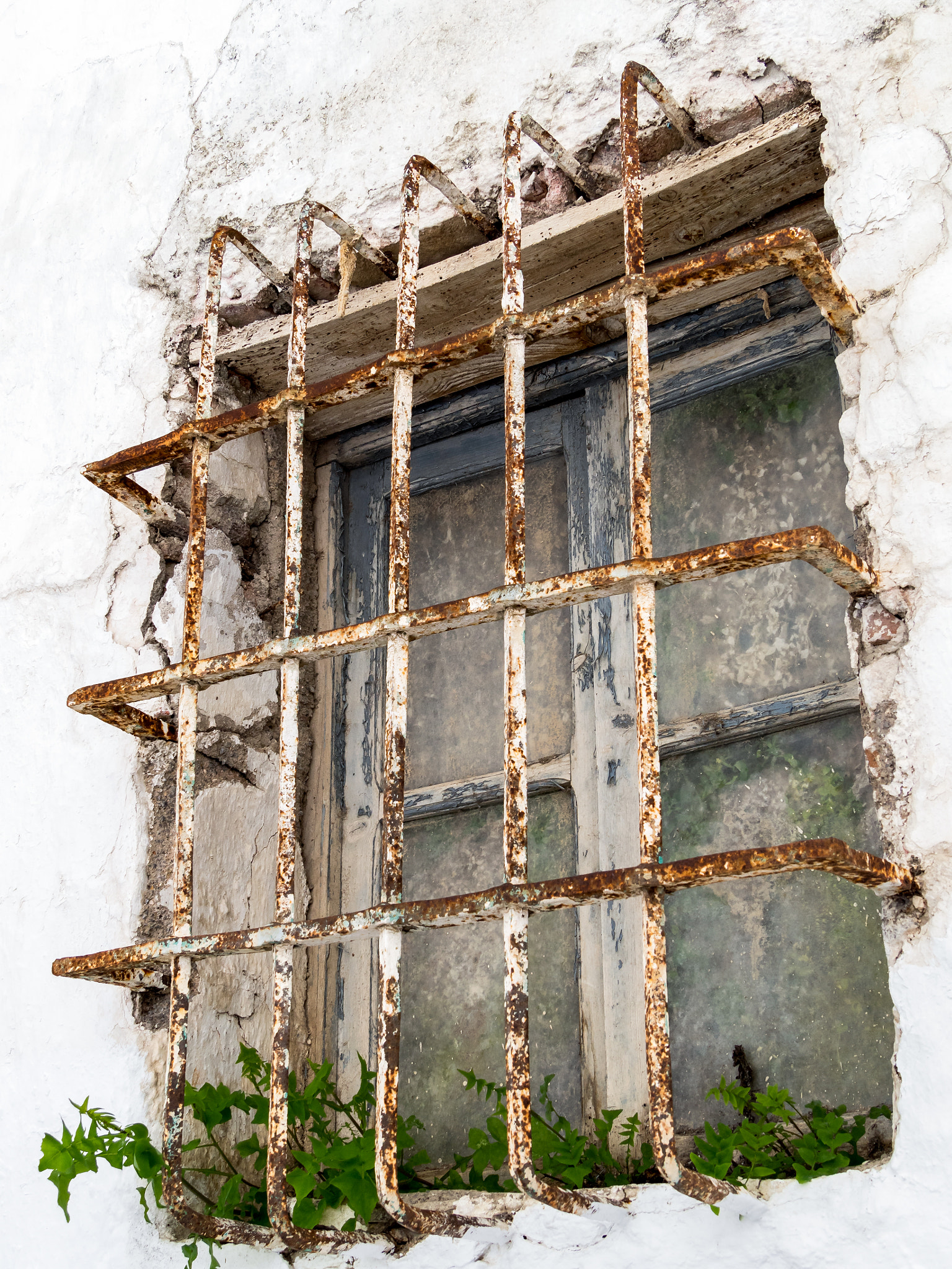 Olympus OM-D E-M1 + Panasonic Lumix G Vario 14-140mm F3.5-5.6 ASPH Power O.I.S sample photo. Rusting bars across a window of a derelict building in casares s photography