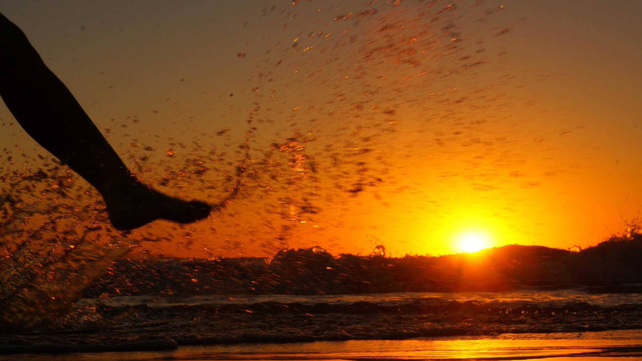 Sony E 18-55mm F3.5-5.6 OSS sample photo. Feet splashing sunset beach () photography