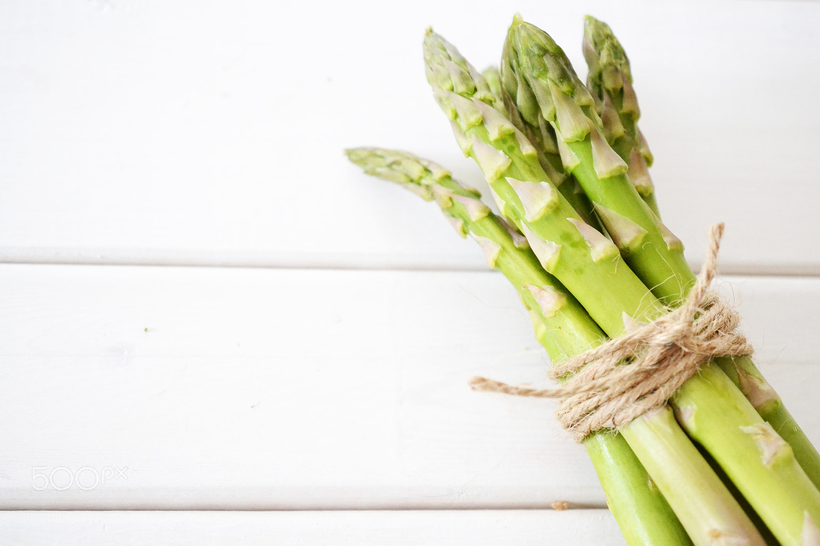 Nikon D3100 + AF Zoom-Nikkor 24-50mm f/3.3-4.5 sample photo. Asparagus tied with twine on white background photography