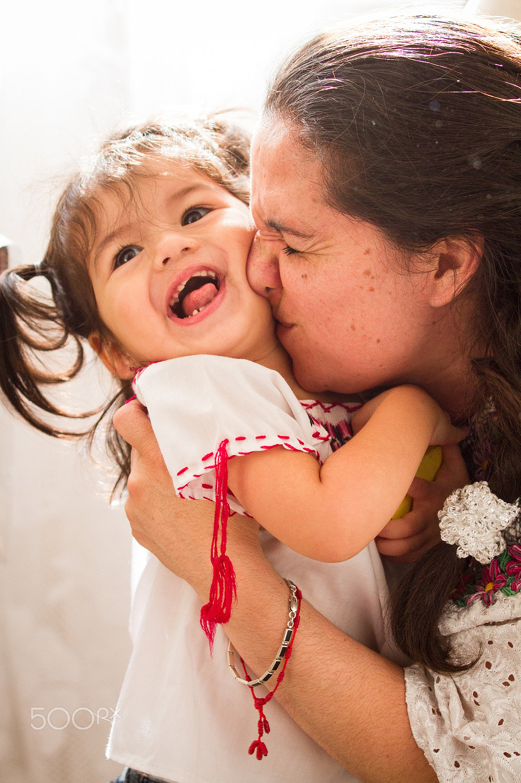 Tamron SP AF 70-200mm F2.8 Di LD (IF) MACRO sample photo. A hispanic woman kissing her daugher on the cheek photography
