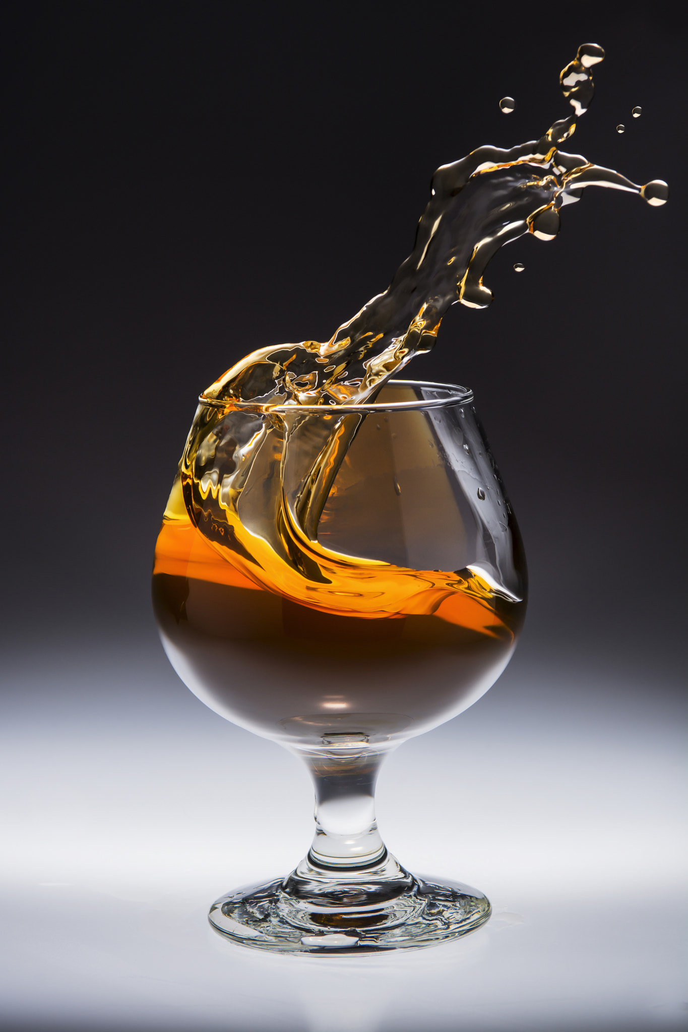 Nikon AF-S Nikkor 28-70mm F2.8 ED-IF sample photo. Amber alcoholic drink splashing in a glass photography