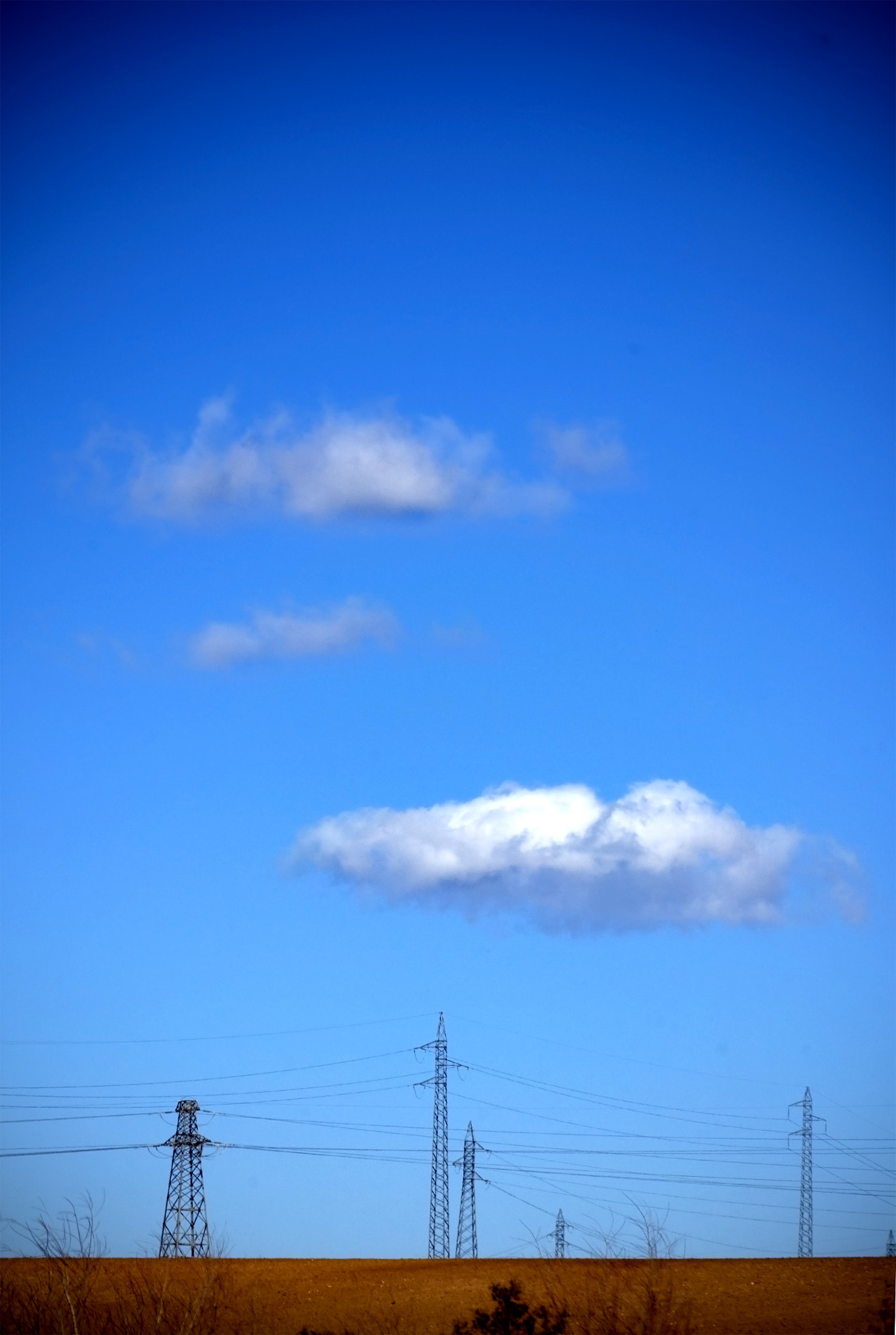 Nikon D200 sample photo. Electricity pylons with white clouds on blue sky photography