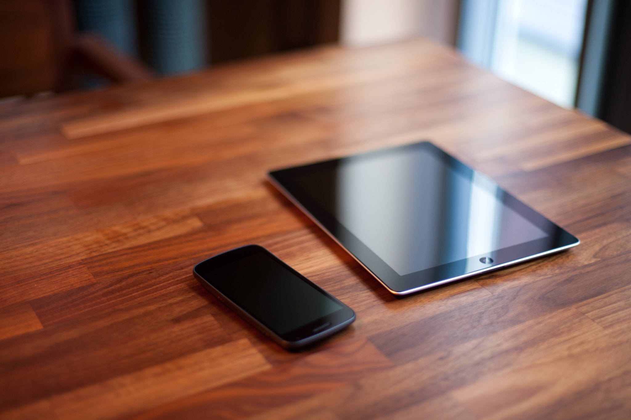 Android phone and iPad on a wooden table