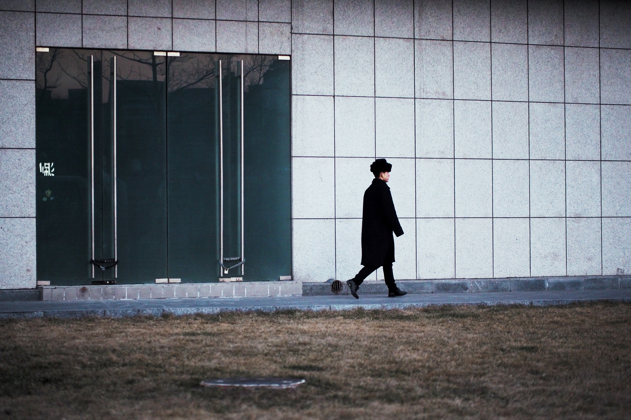 Panasonic Leica DG Nocticron 42.5mm F1.2 ASPH OIS sample photo. Young man passing by photography