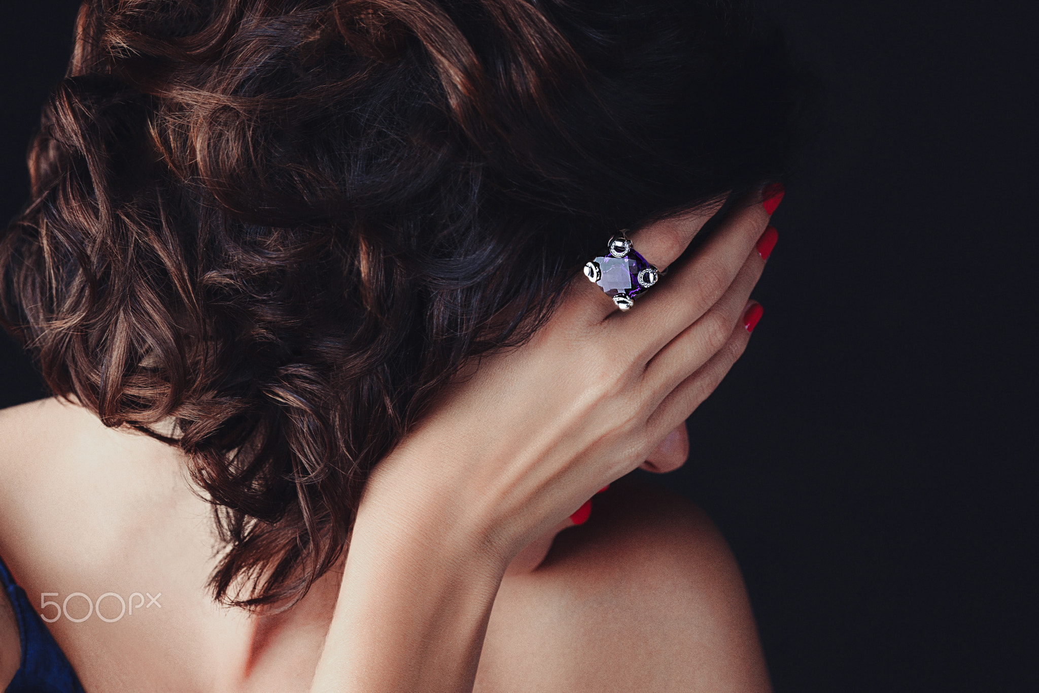 Woman, covering her face, a supphire ring