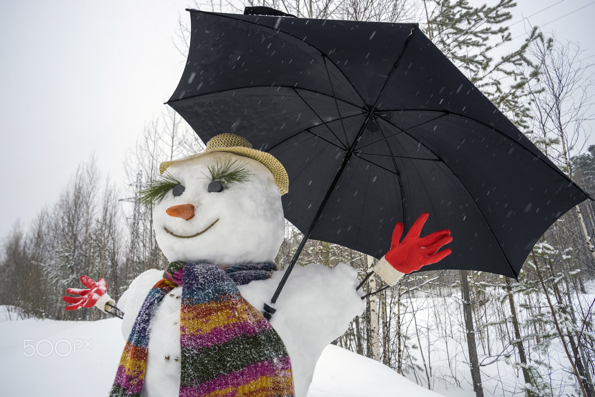 Funny snowman with an umbrella.