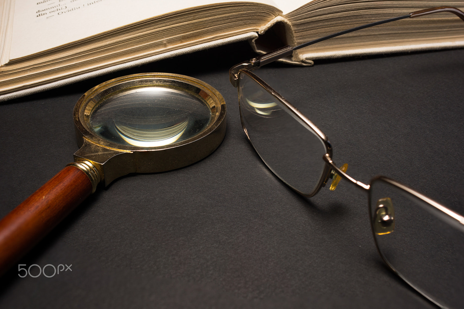 Sony SLT-A77 + Minolta AF 28-85mm F3.5-4.5 sample photo. Eyeglasses with magnifying glass on dark surface with books. photography