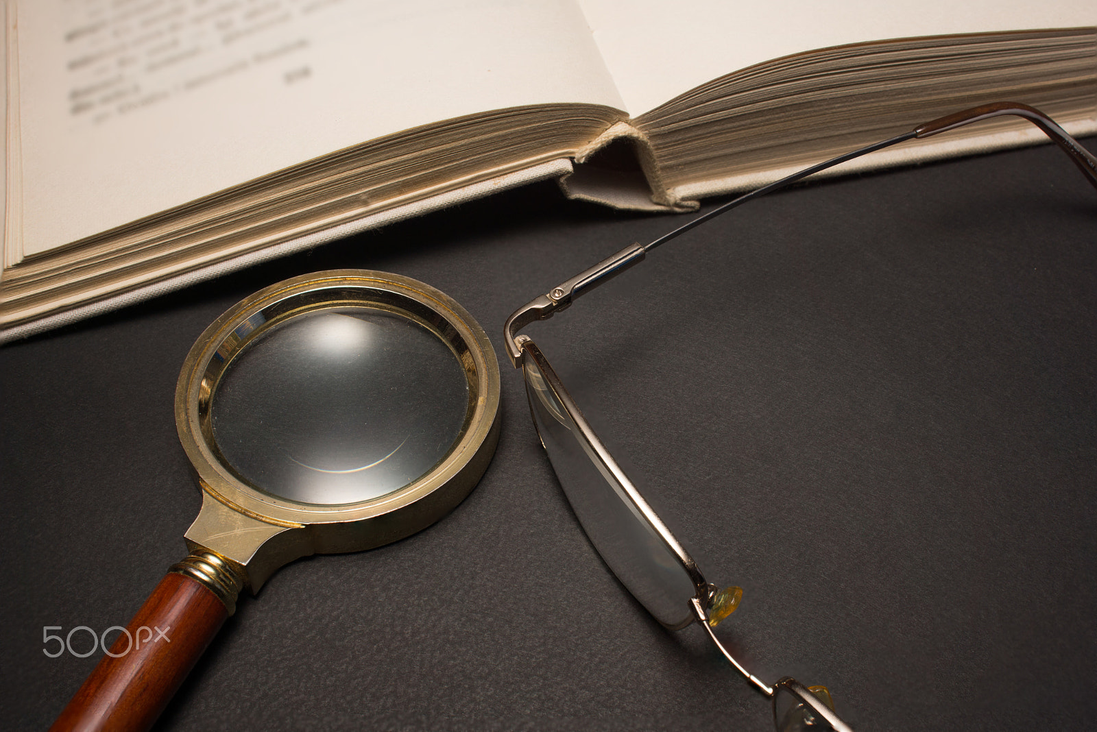 Sony SLT-A77 + Minolta AF 28-85mm F3.5-4.5 sample photo. Eyeglasses with magnifying glass on dark surface with books. photography