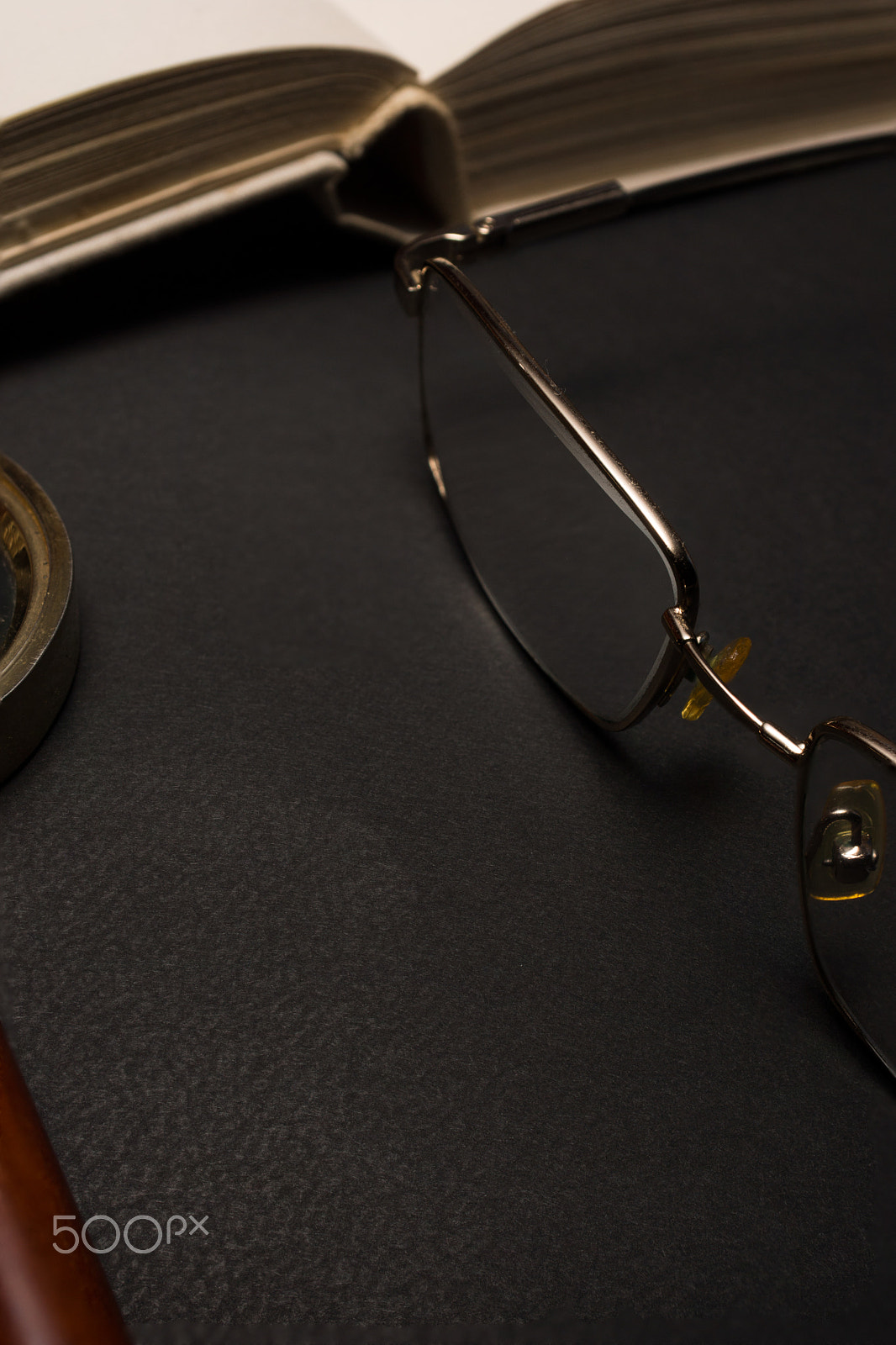 Sony SLT-A77 + Minolta AF 28-85mm F3.5-4.5 sample photo. Eyeglasses with magnifying glass on dark surface with books. photography