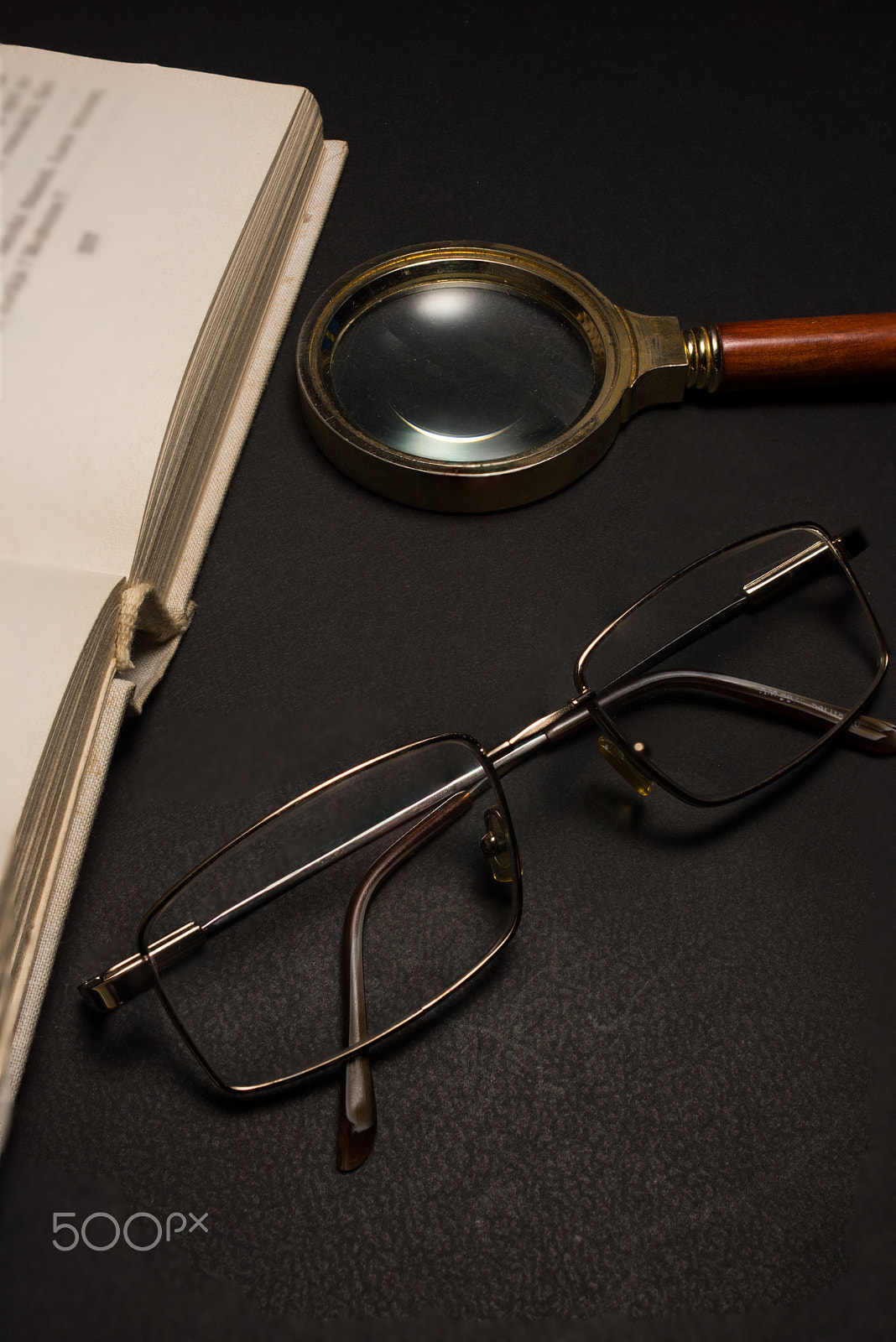 Sony SLT-A77 + Minolta AF 28-85mm F3.5-4.5 sample photo. Eyeglasses with magnifying glass on dark surface with books. photography