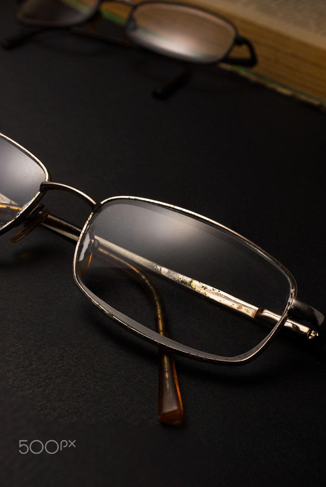 Sony SLT-A77 + Minolta AF 28-85mm F3.5-4.5 sample photo. Eyeglasses with magnifying glass on dark surface with books. photography