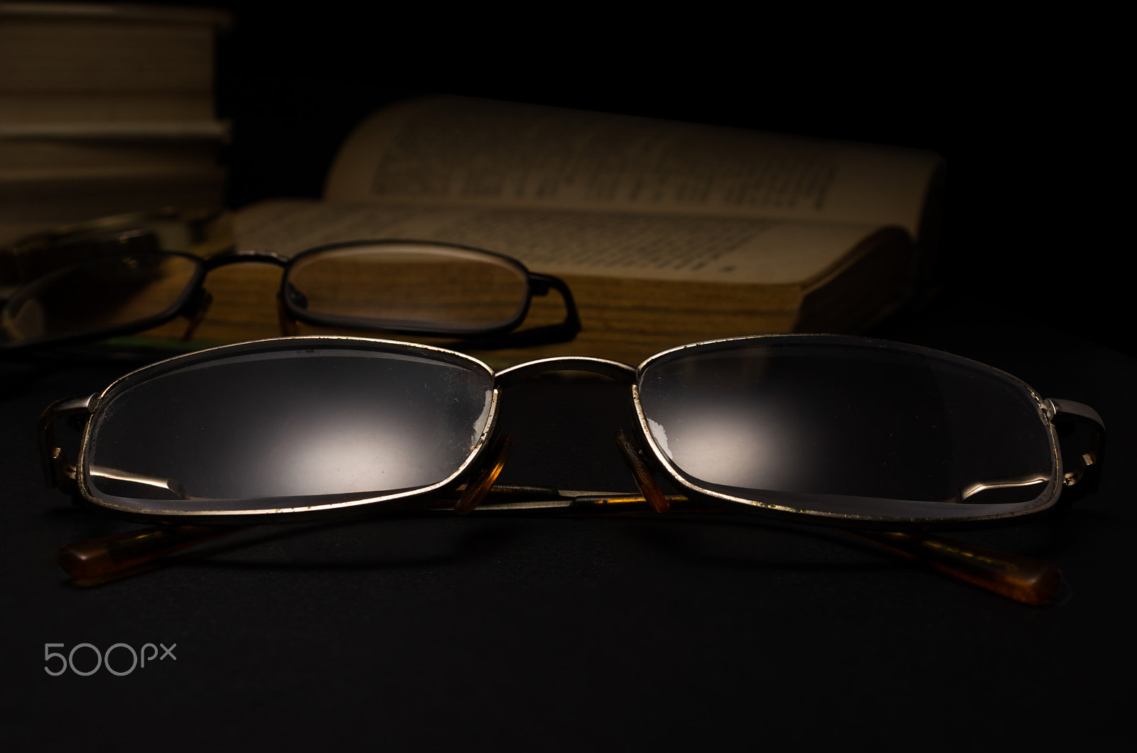 Sony SLT-A77 + Minolta AF 28-85mm F3.5-4.5 sample photo. Eyeglasses with magnifying glass on dark surface with books. photography