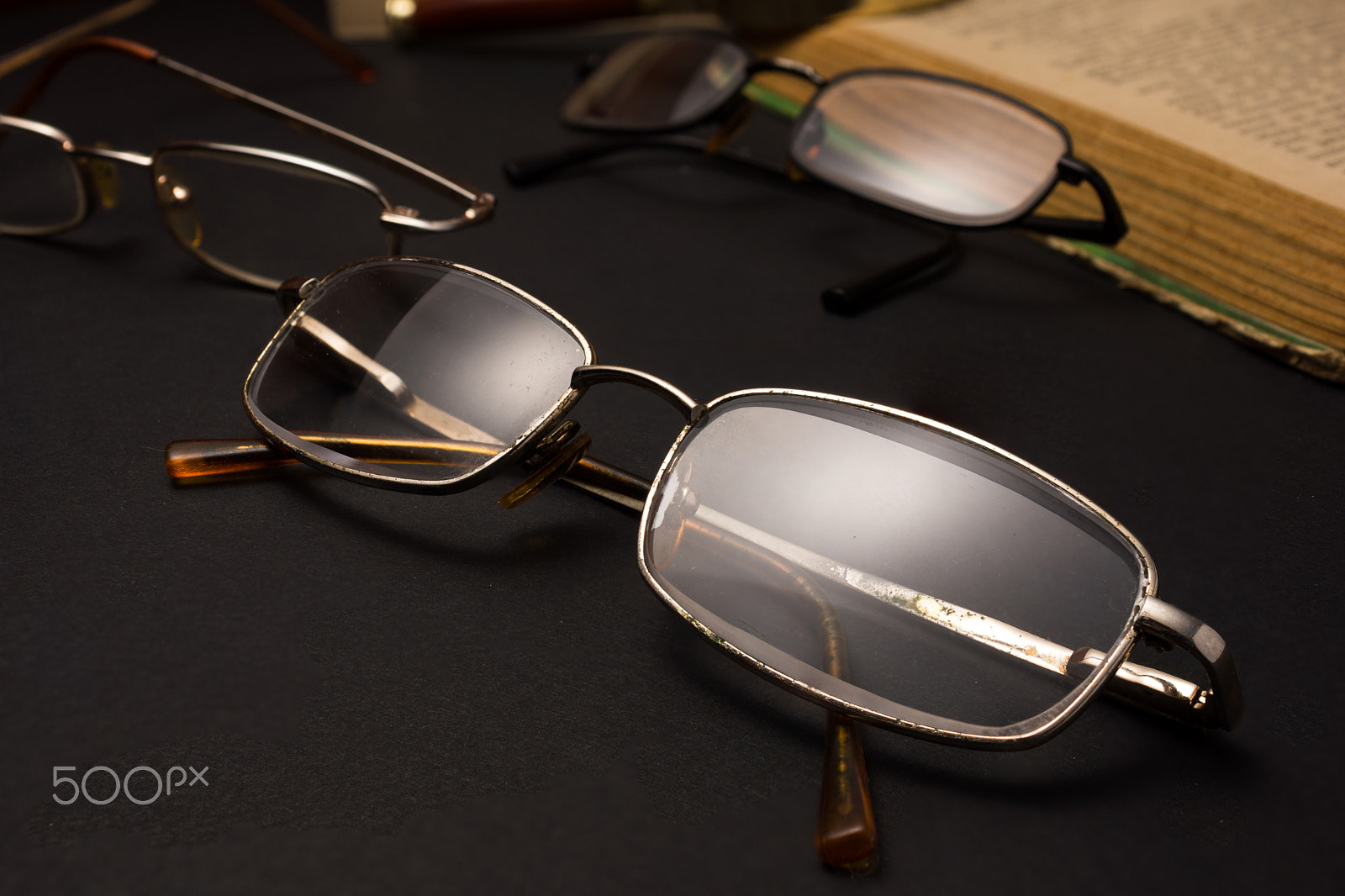 Sony SLT-A77 + Minolta AF 28-85mm F3.5-4.5 sample photo. Eyeglasses with magnifying glass on dark surface with books. photography
