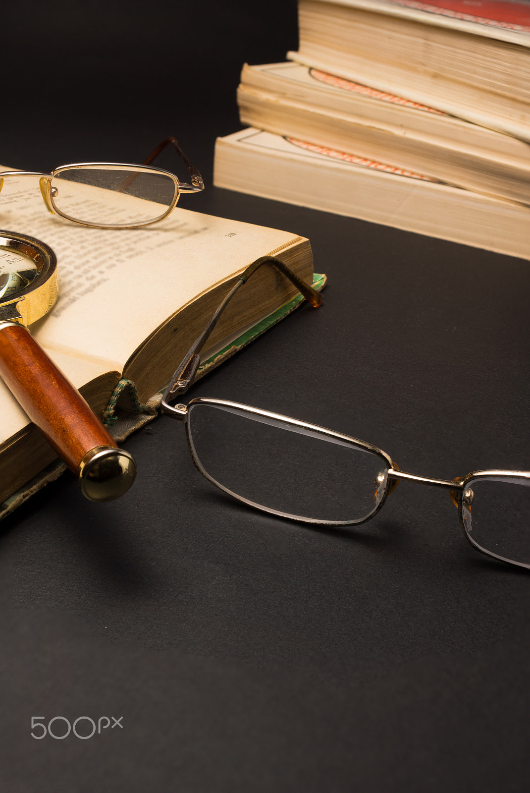 Sony SLT-A77 + Minolta AF 28-85mm F3.5-4.5 sample photo. Eyeglasses with magnifying glass on dark surface with books. photography