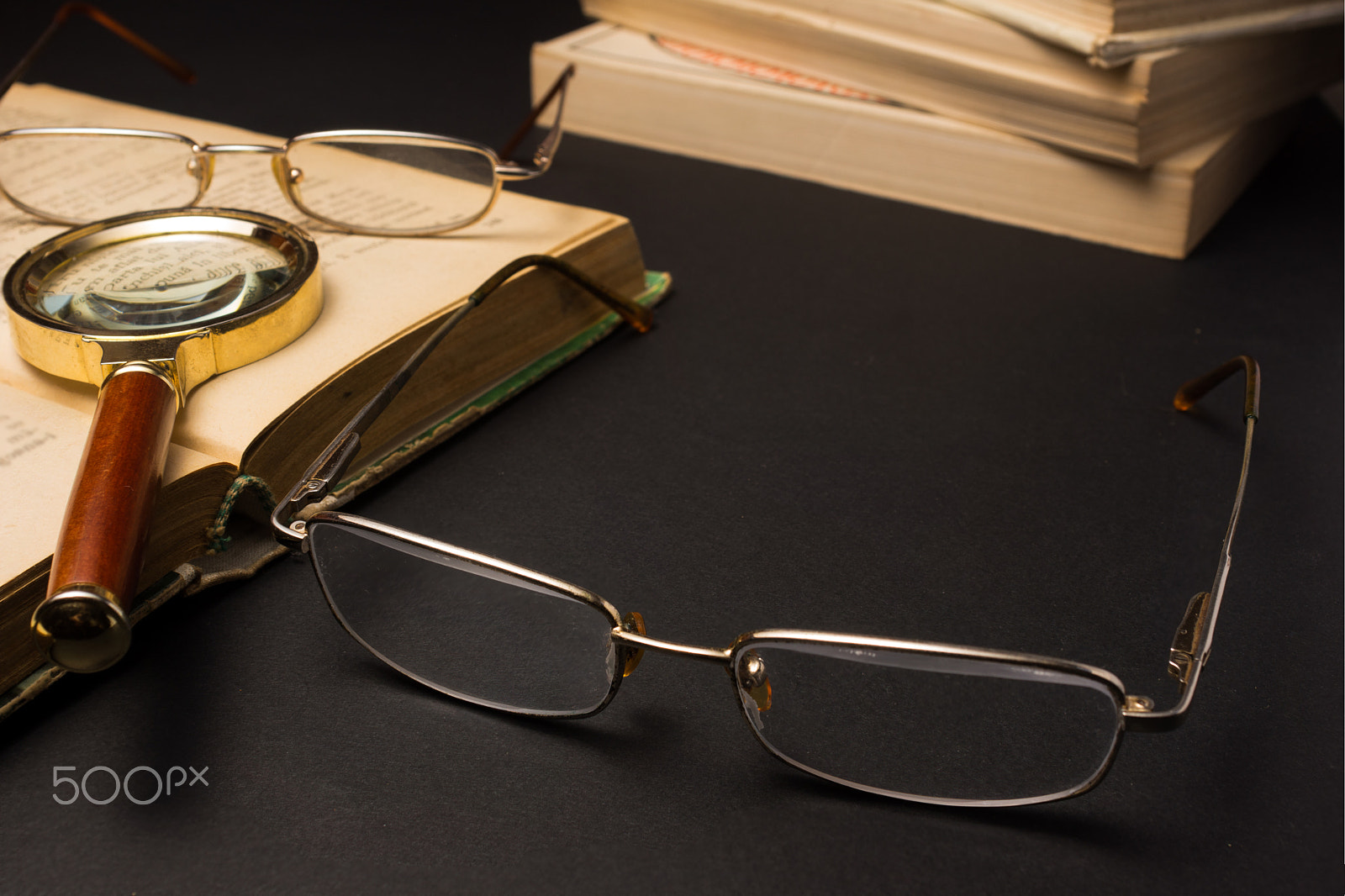 Sony SLT-A77 + Minolta AF 28-85mm F3.5-4.5 sample photo. Eyeglasses with magnifying glass on dark surface with books. photography