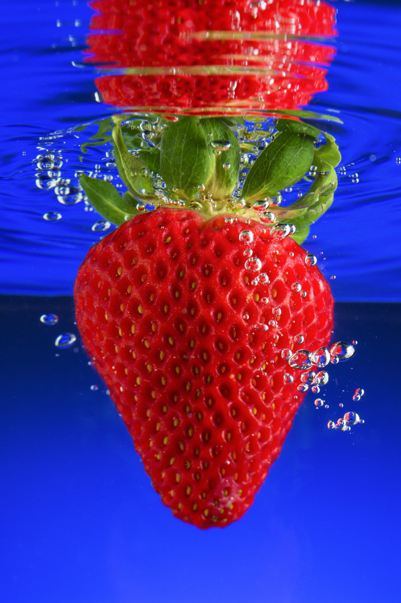 Nikon PC-E Micro-Nikkor 85mm F2.8D Tilt-Shift sample photo. Fresh strawberry splashing into blue water photography