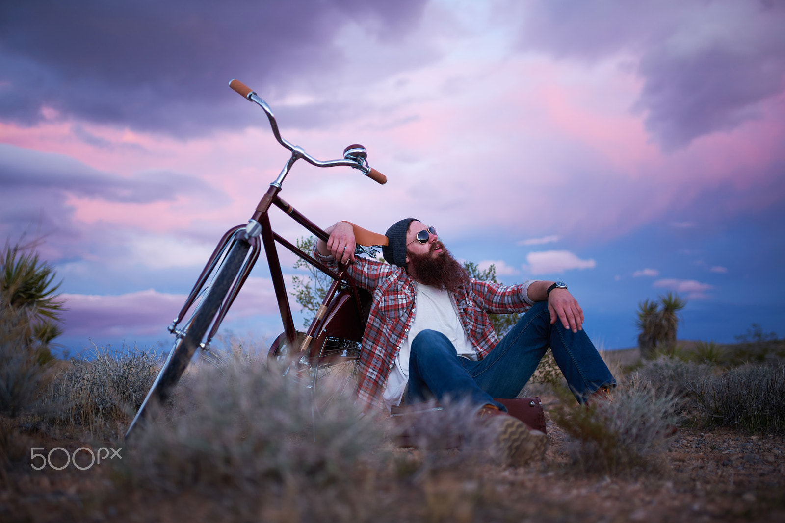 Sony a7R II + 35mm F1.4 G SSM sample photo. Man sitting with bike on suitcase in middle of the desert photography