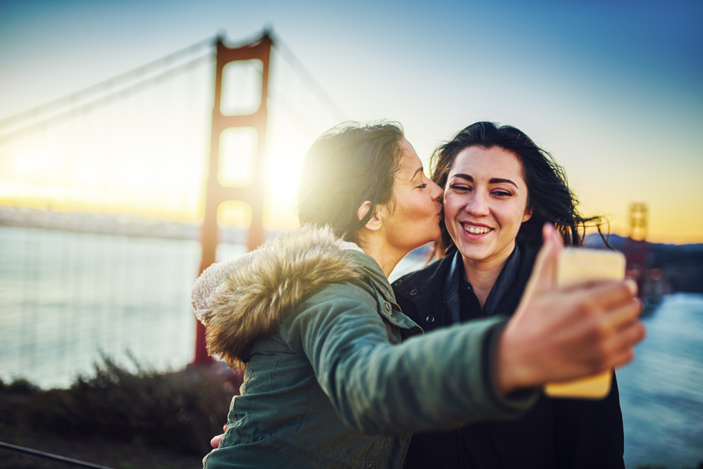 lesbian couple taking selfie in front of golden gate bridge by Joshua Resnick on 500px.com