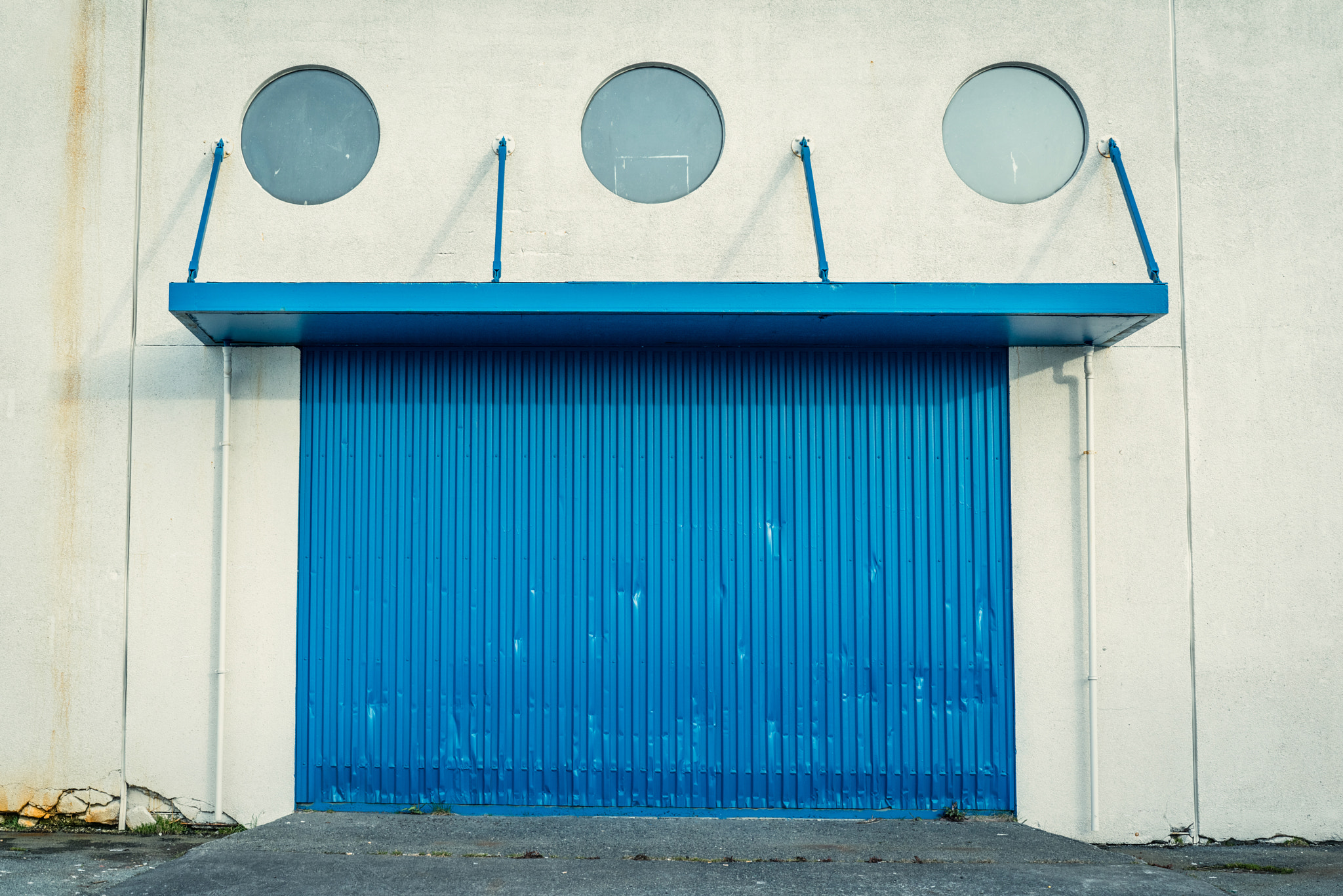 Sony a7R + Sony 50mm F1.4 sample photo. Blue gate on a grungy wall photography