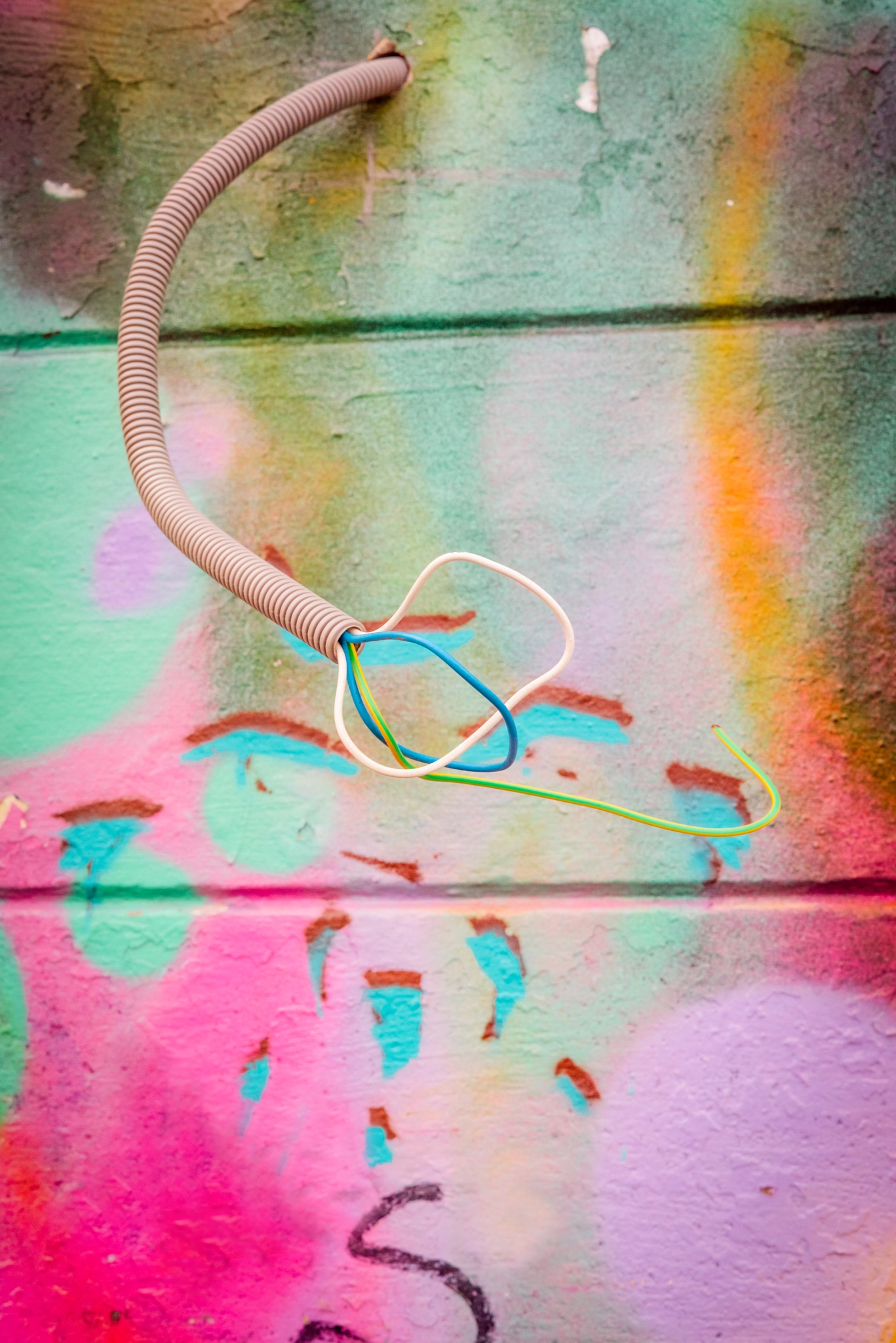 Sony a7R + Sony 50mm F1.4 sample photo. Wires coming out of a grungy wall with grafitti photography