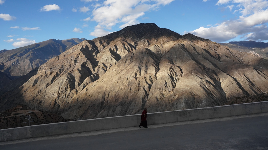 Sony E 16-50mm F3.5-5.6 PZ OSS sample photo. A tibetan monk walking before mountain photography