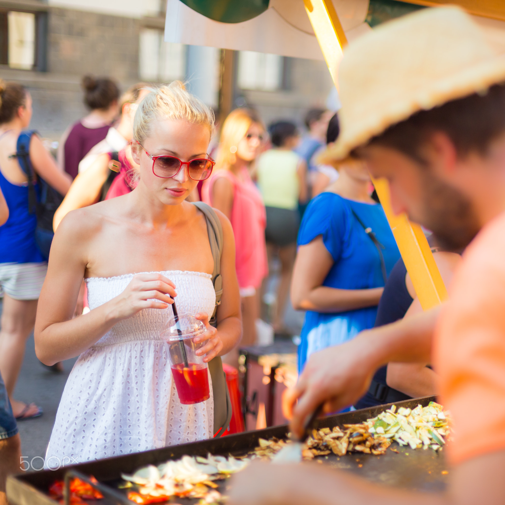 Woman buying meal at street food festival.