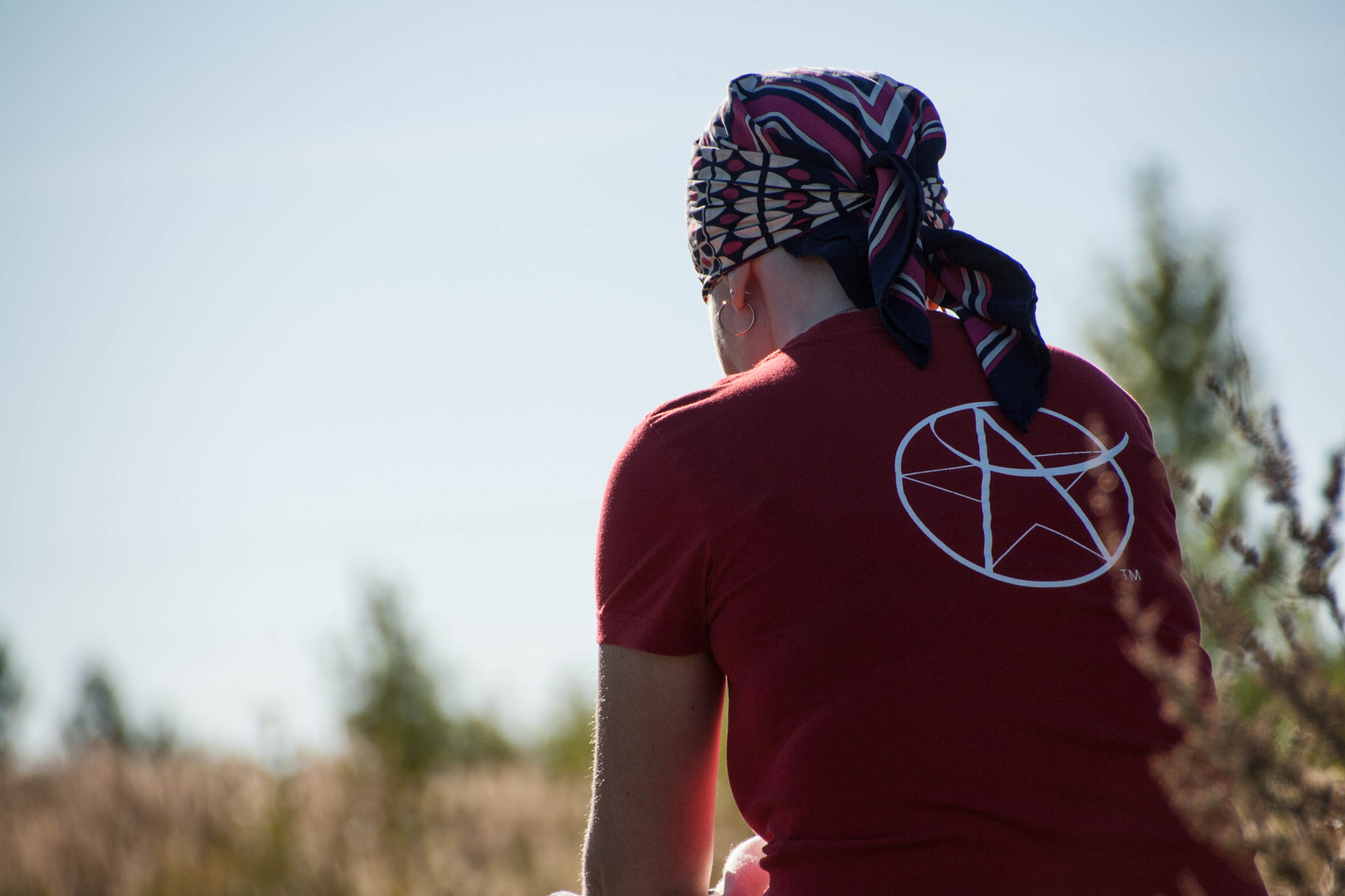 Canon EOS 1000D (EOS Digital Rebel XS / EOS Kiss F) sample photo. Young woman sits  a field in headscarf photography