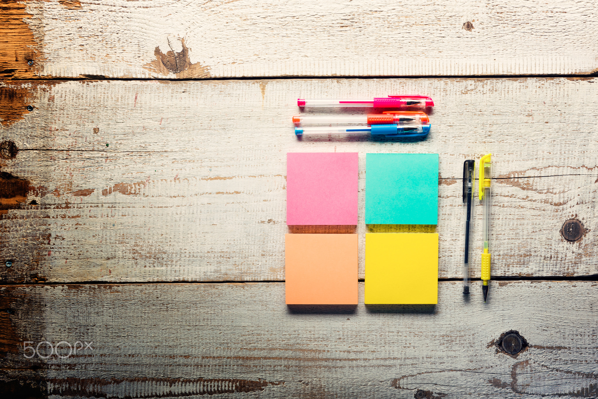 Retro white wooden table with empty colorful sticky notes and different gel pens