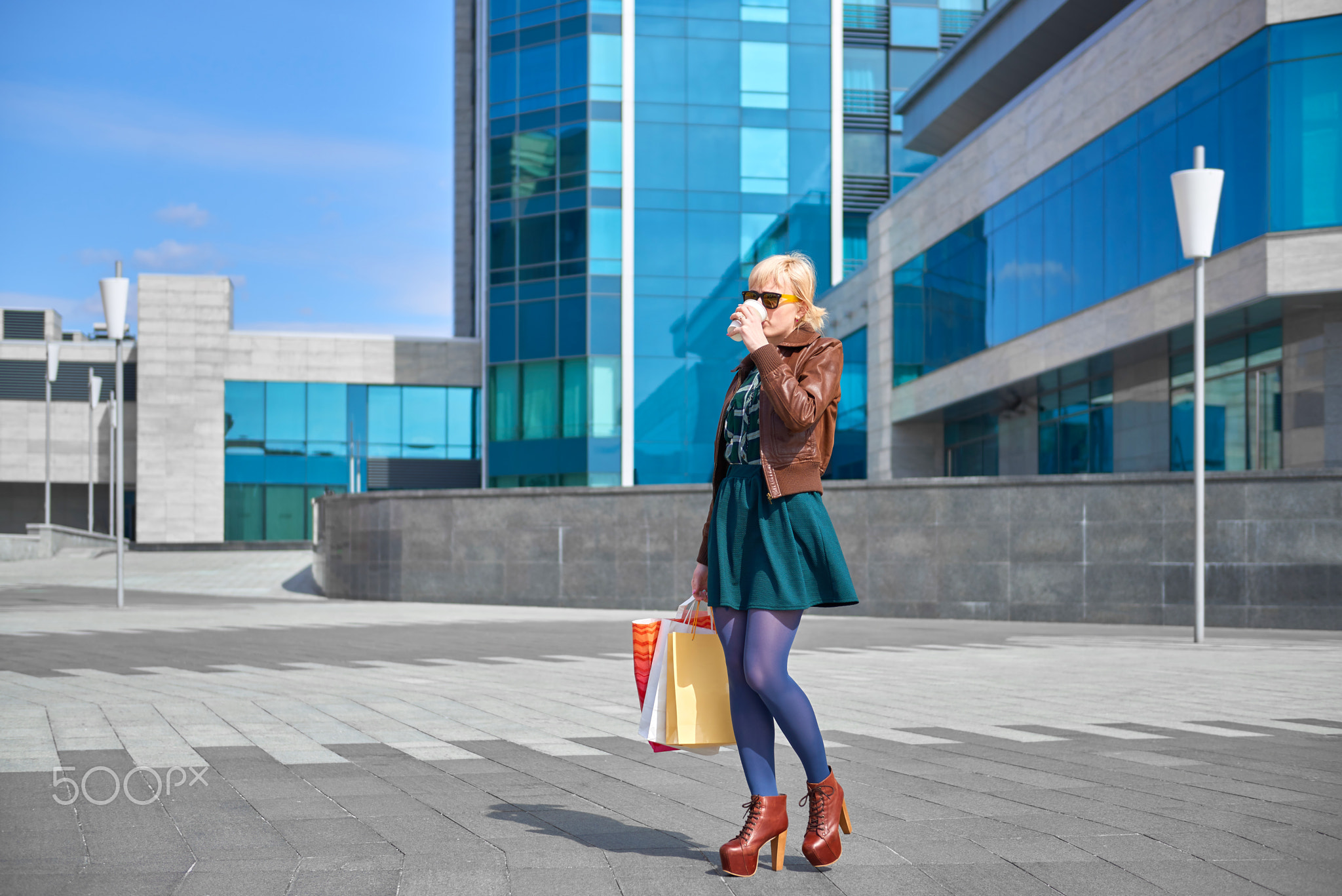 Beautiful woman drinking coffee with shopping bags
