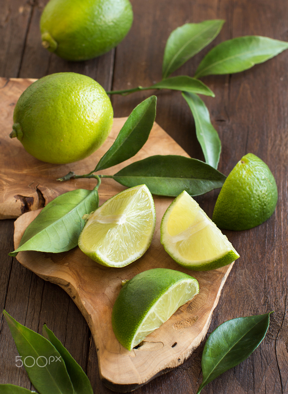 Canon EOS 650D (EOS Rebel T4i / EOS Kiss X6i) + Canon EF 50mm F1.2L USM sample photo. Fresh limes with leaves on a wooden table photography