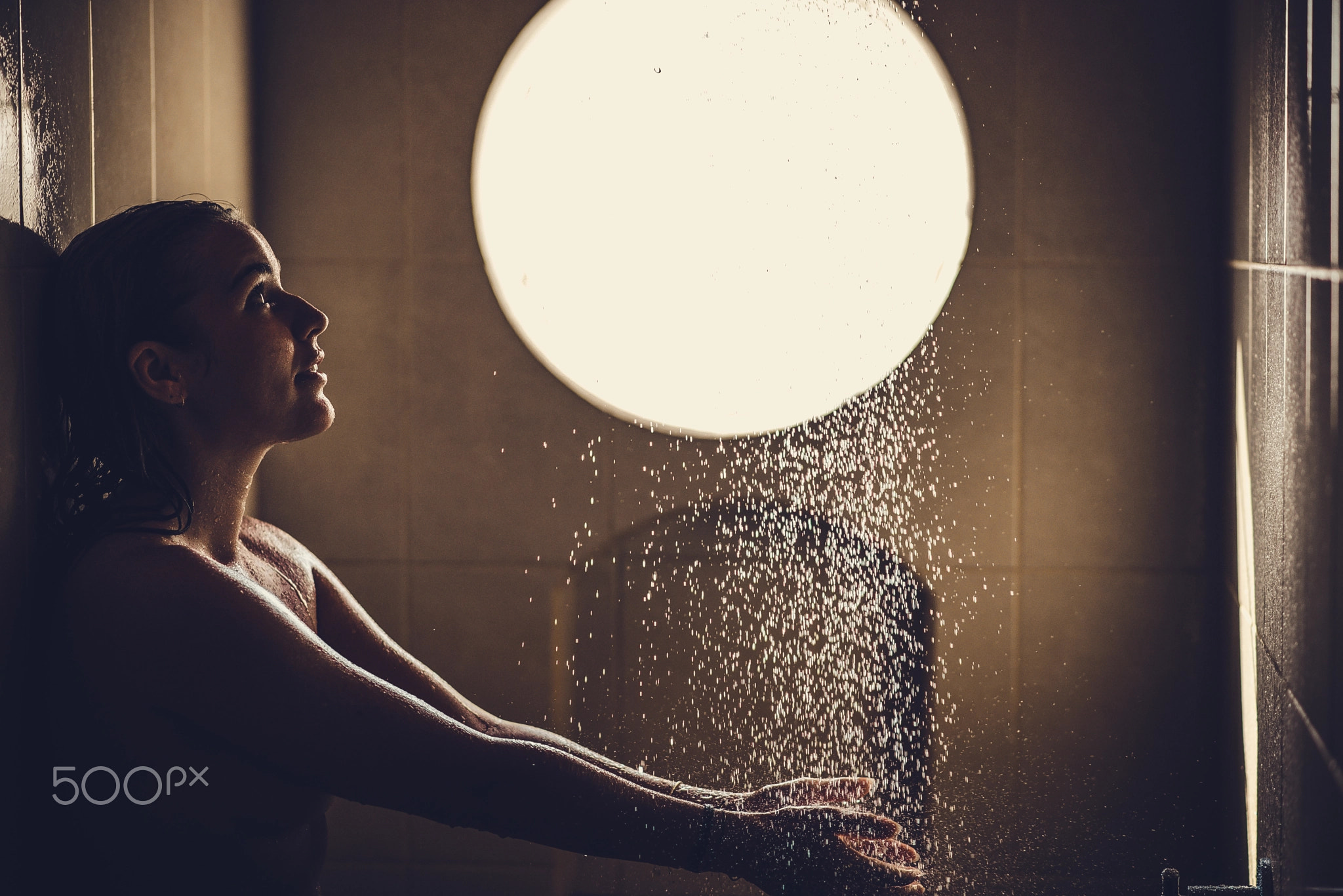 Beautiful woman waiting for warm water in a shower