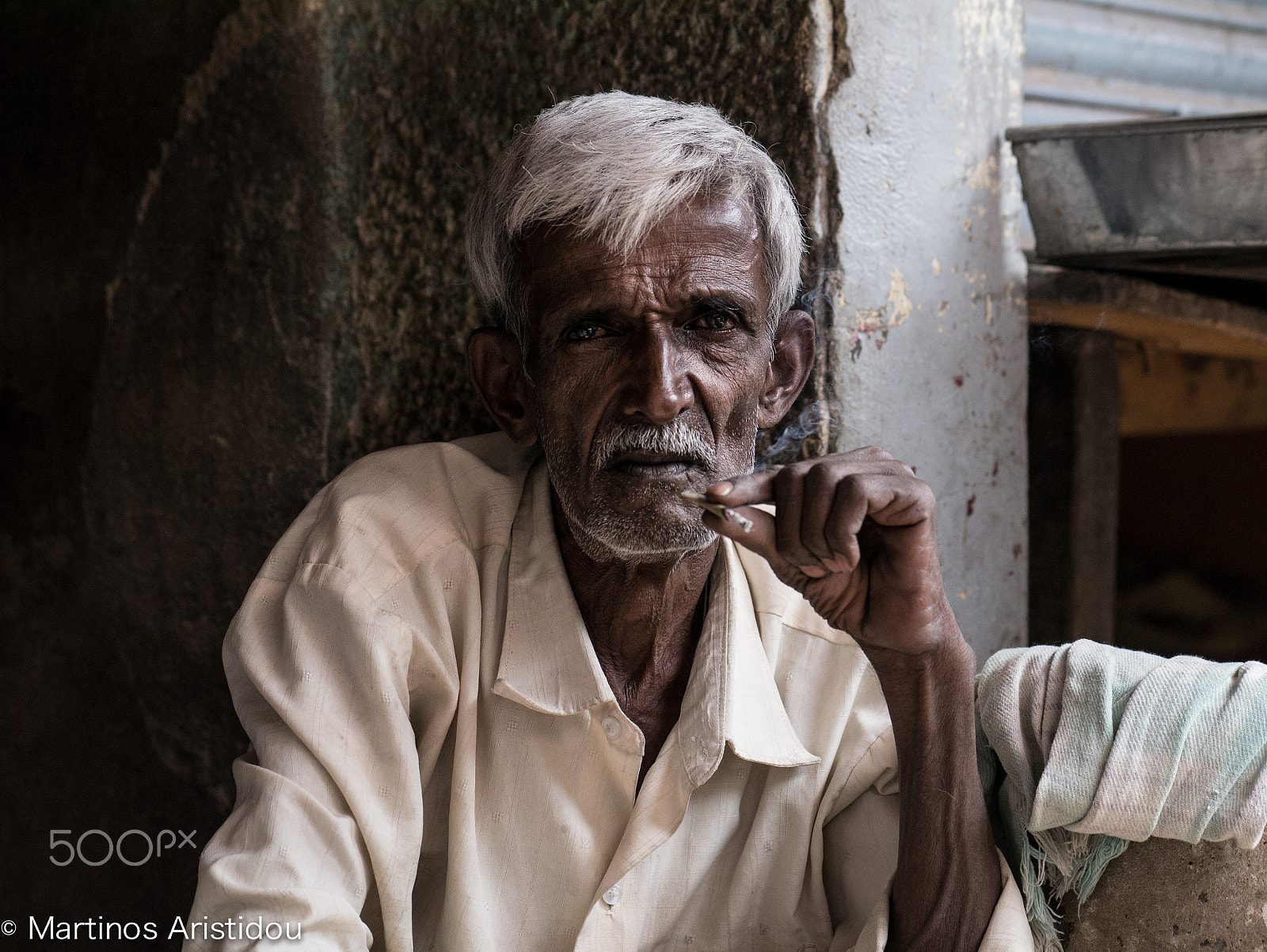 Panasonic Lumix DMC-GX1 + Panasonic Leica DG Nocticron 42.5mm F1.2 ASPH OIS sample photo. Portrait of a man smoking photography